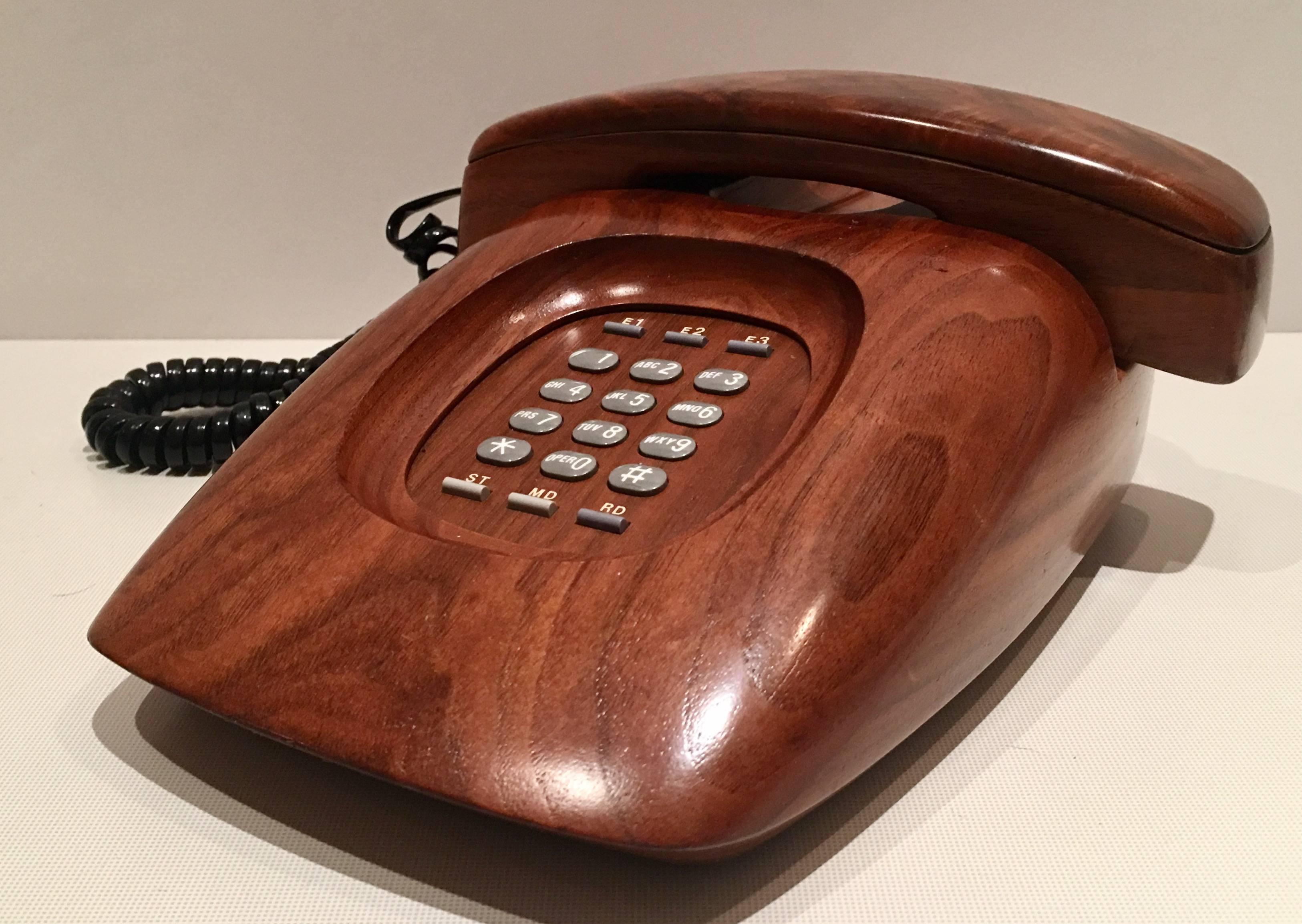 Executive walnut wood Mid-Century Modern American push button telephone.
Fully tested and in operating condition. Made by WCC Wood Communications Co. in Seattle Washington, Model No. E100, original manufacturer information on the underside.