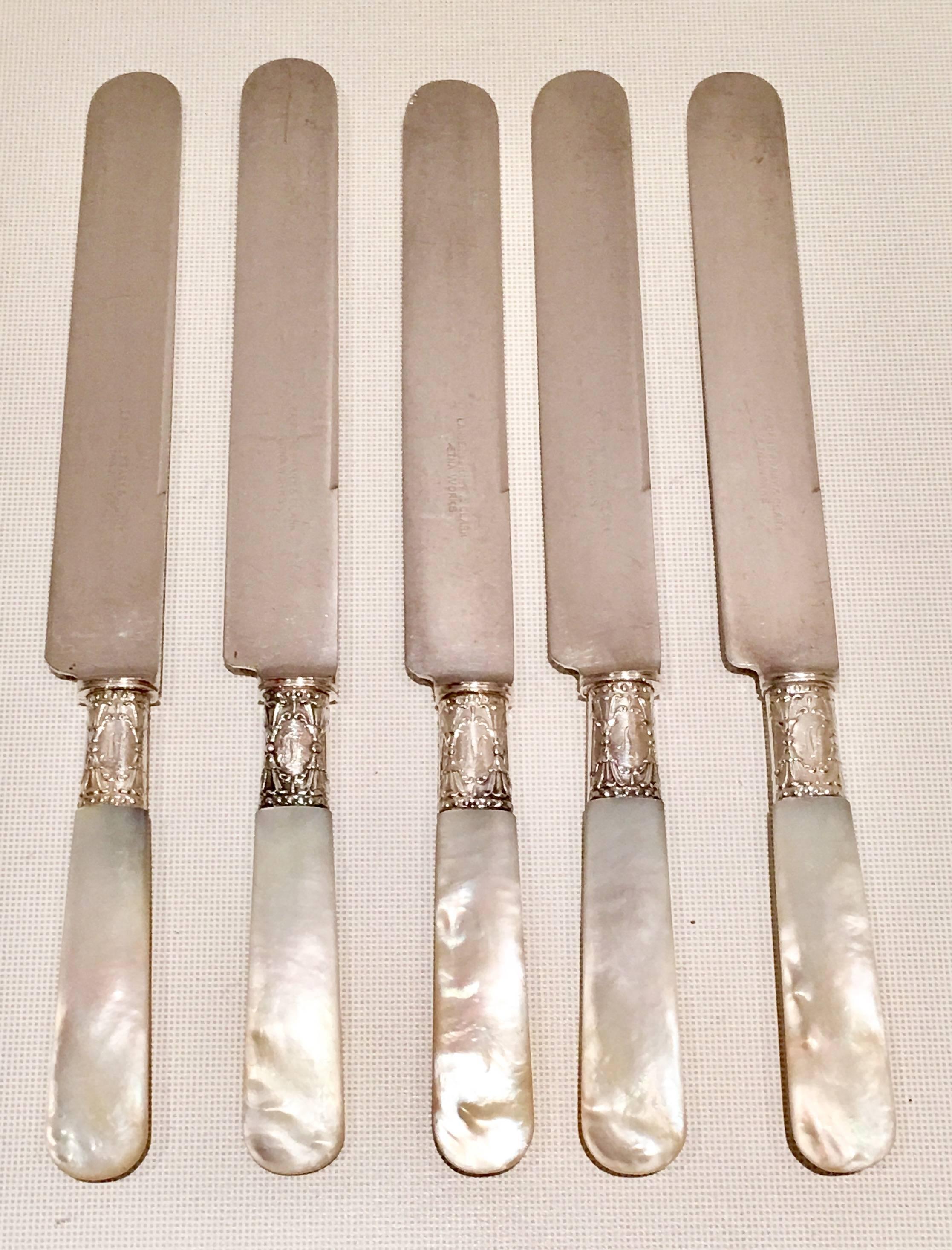 Early 20th century sterling silver and mother-of-pearl handle art nouveau flatware, 21 pieces. Set includes, five dinner knives, six dessert knives, four dinner/dessert forks and six cheese/spreader knives. Each piece is signed and carries the