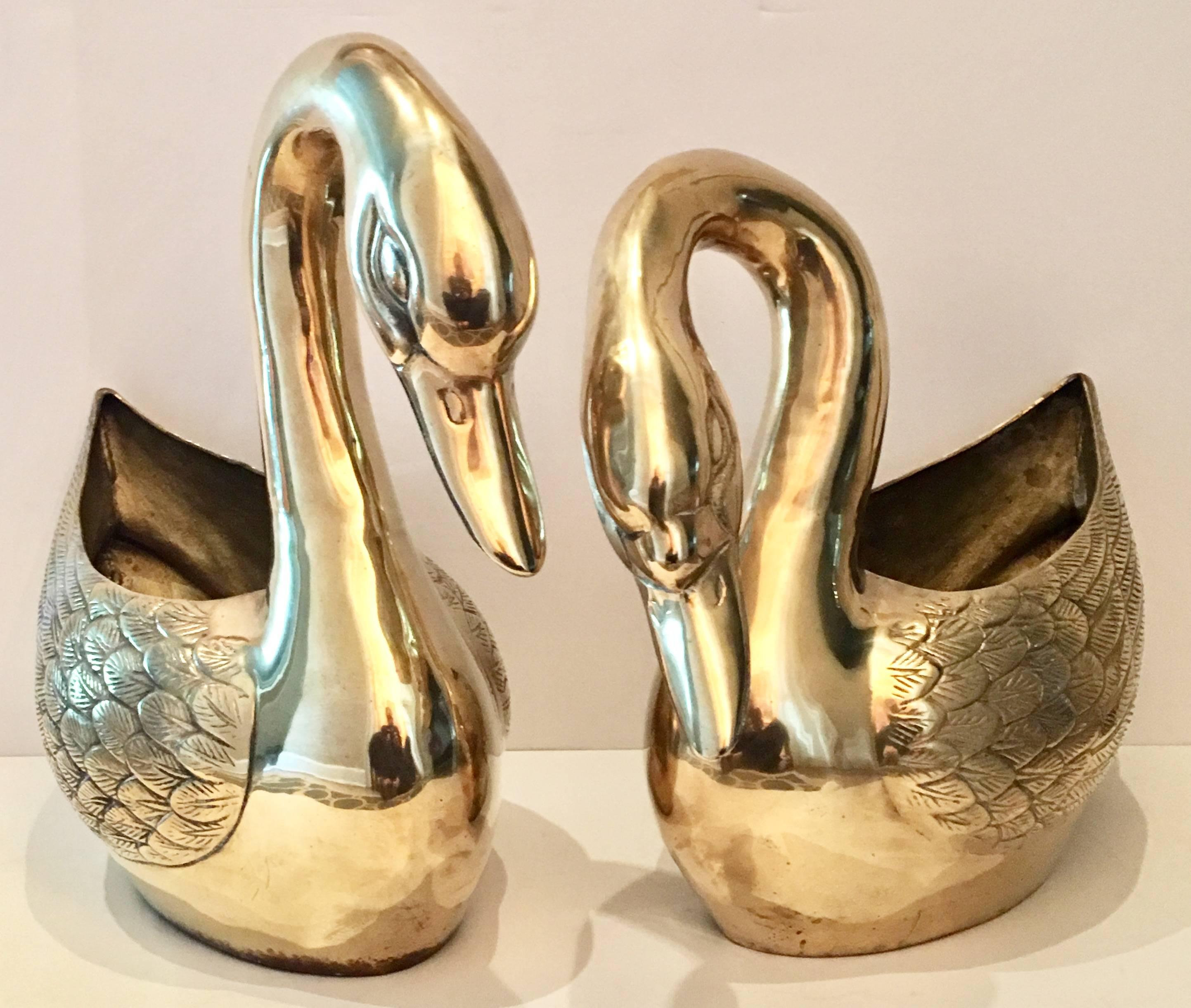 Vintage pair of etched brass swan sculpture planters. The smaller swan measures, Measures: 15" inches H x 17" W x 9" L.