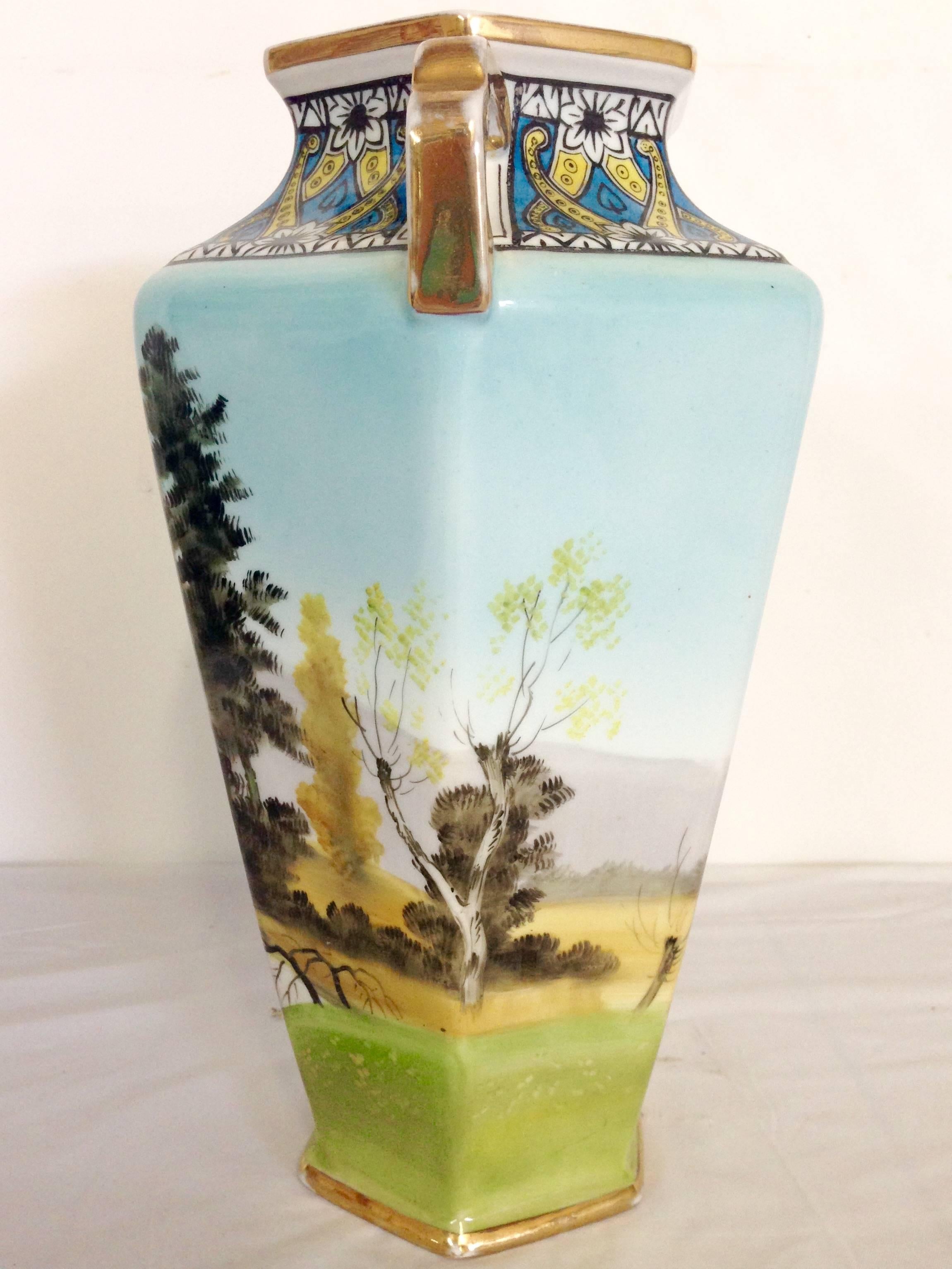 Rare Japanese porcelain hand-painted vase with 22-karat gold detail singed, Noritake-Morimura. Incredible Art Deco bird motif at neck with a mountain, lake, lake house and palm tree landscape motif. This vase features six panels and is two