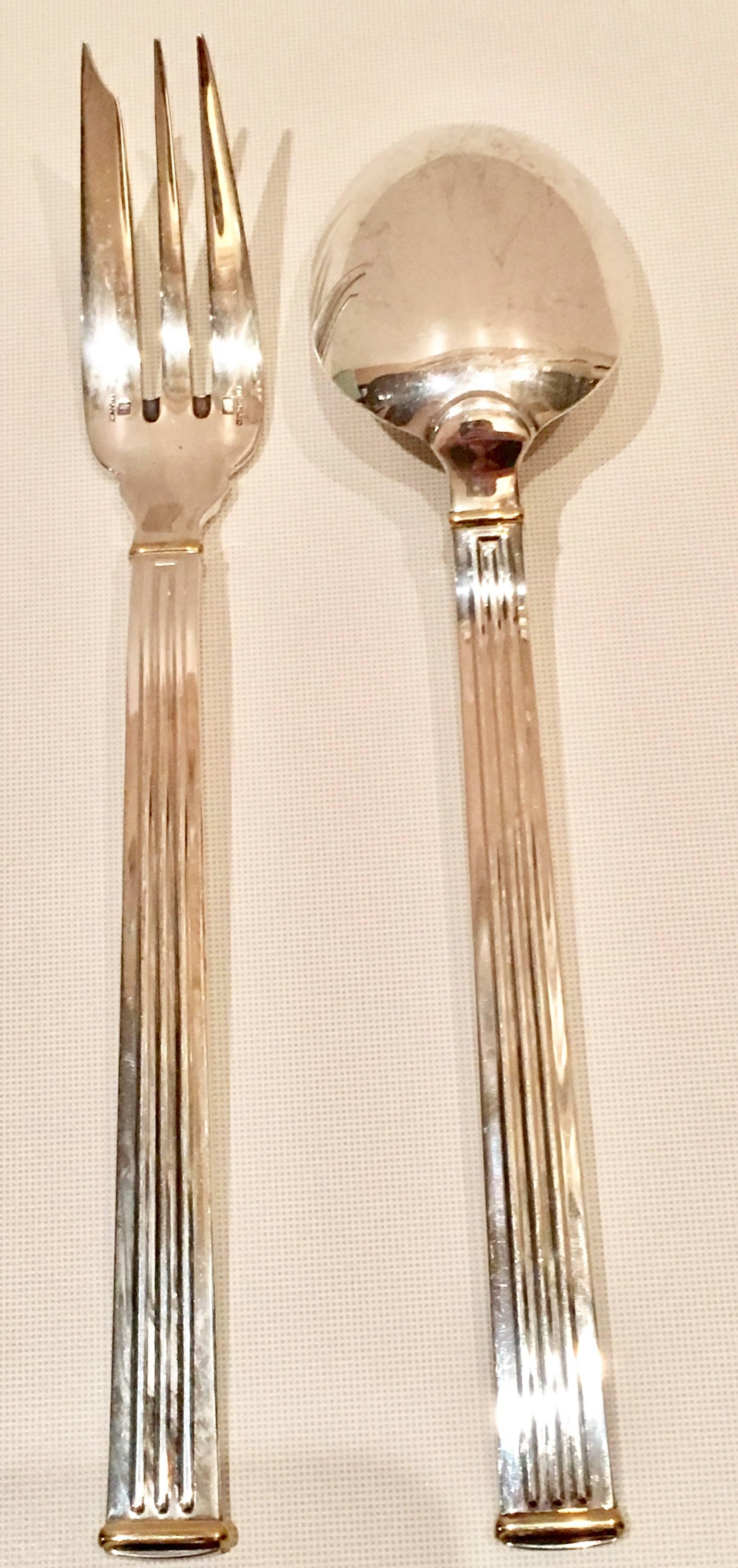 Iconic French silversmith Christofle Silver Paris Inc. 27-piece flatware set in "Triade Gold". Modern clean lines in a Classic column motif with 24-karat gold detail makes this pattern, "Triade Gold" forever timeless. The pieces