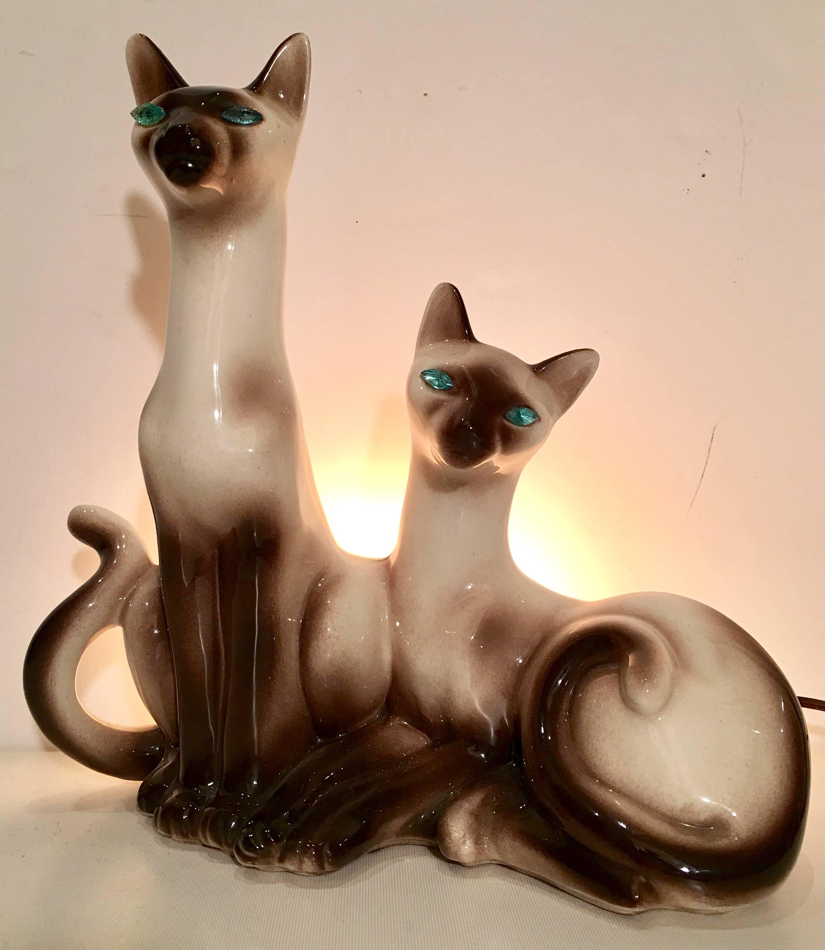 Mid-Century American glazed ceramic Siamese cat lamp. Features, sapphire blue rhinestone set eyes. Signed, Lane & Co. Van Nuys Calif. Wired for the US, in working order. Takes a regular light bulb.
 