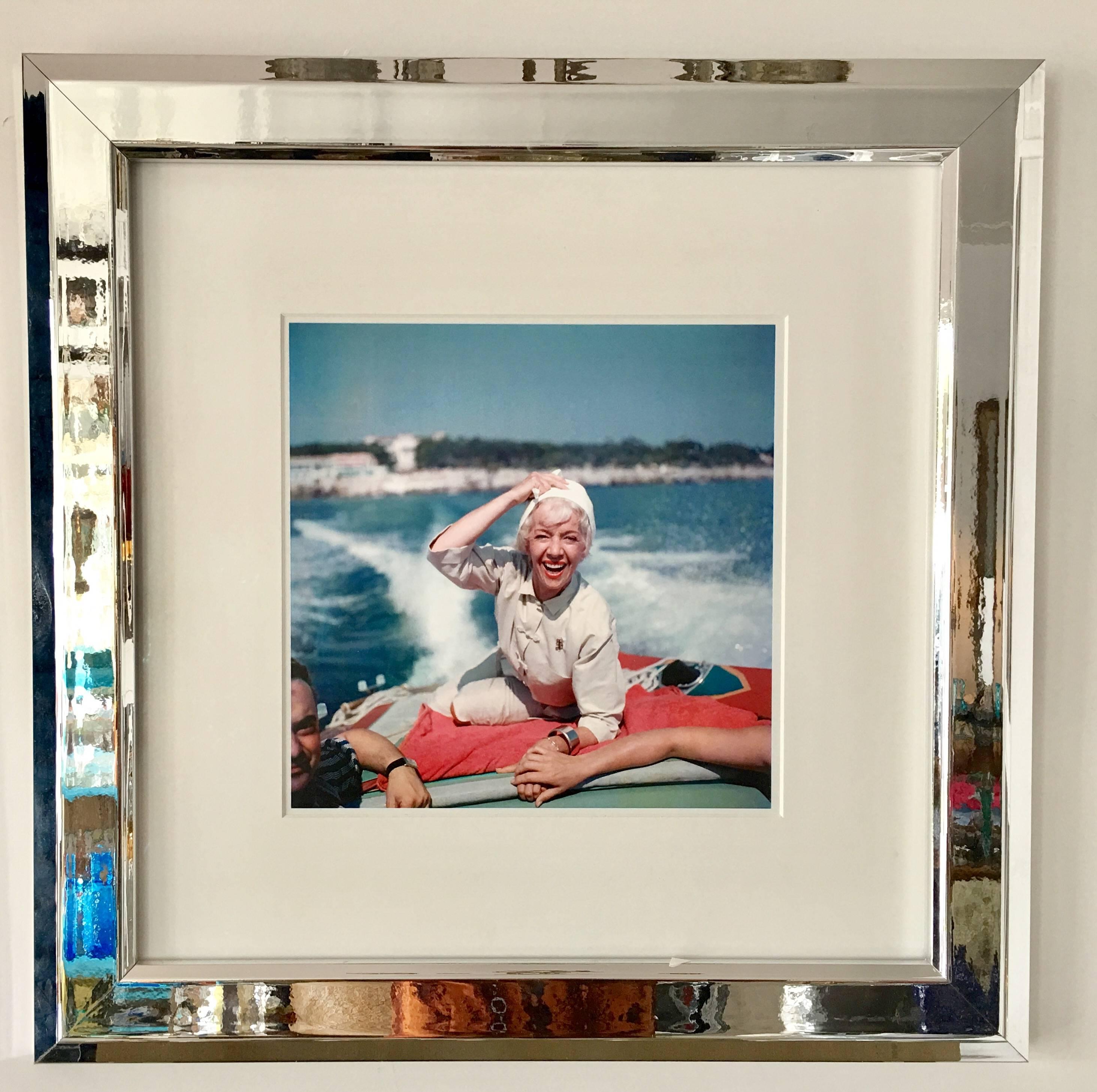 1957 Slim Aarons Estate release photograph of French soprano, Lily Pons (1898-1976) on the back of a speedboat at Cap Ferrat on the French Riviera. Printed from an original negative in London England. Professionally framed with white silk matte and