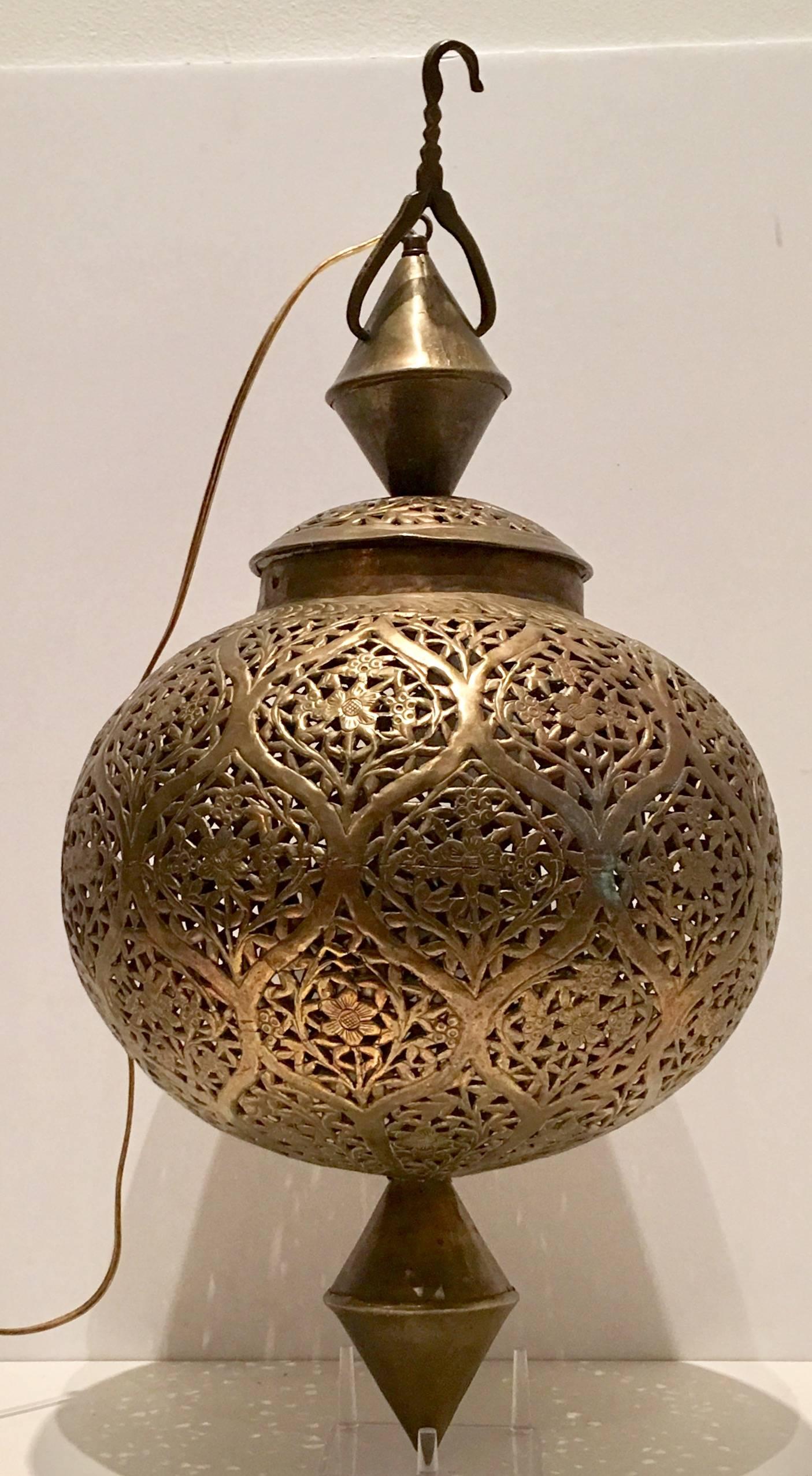This Moroccan brass light fixture is delicately handcrafted and chiselled with fine filigree Art Nouveau floral design by skilled Moroccan artisans. Very interesting hanger style hook design at top. Includes approximately 120" newer brass chain