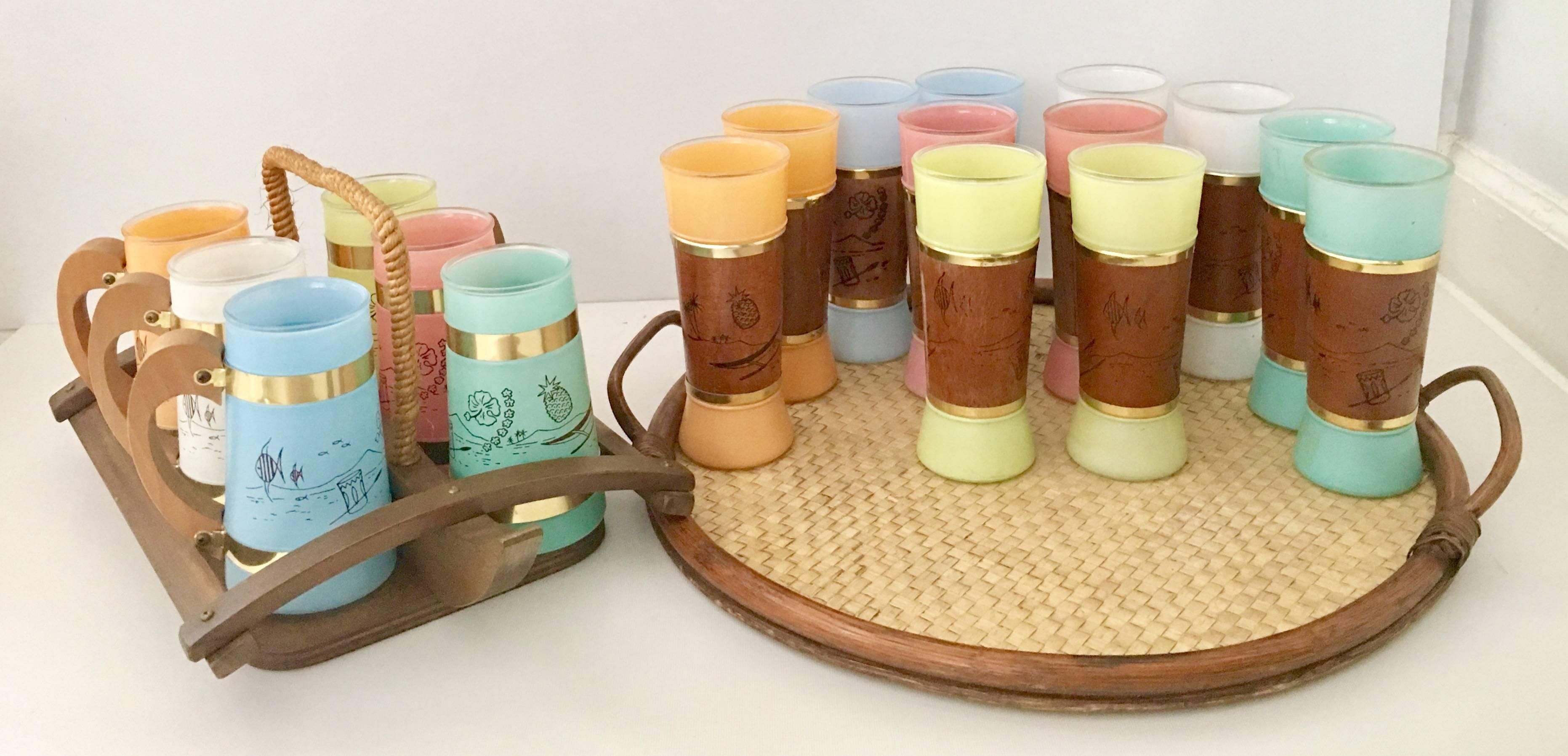 Mid-Century Fiesta Ware 21-piece entertainment set. This Luau themed set includes, six teak wood and brass handle frosted glass steins, 12 mahogany wrapped and brass frosted glasses, one rattan and wicker handle round serving tray and one teak wood