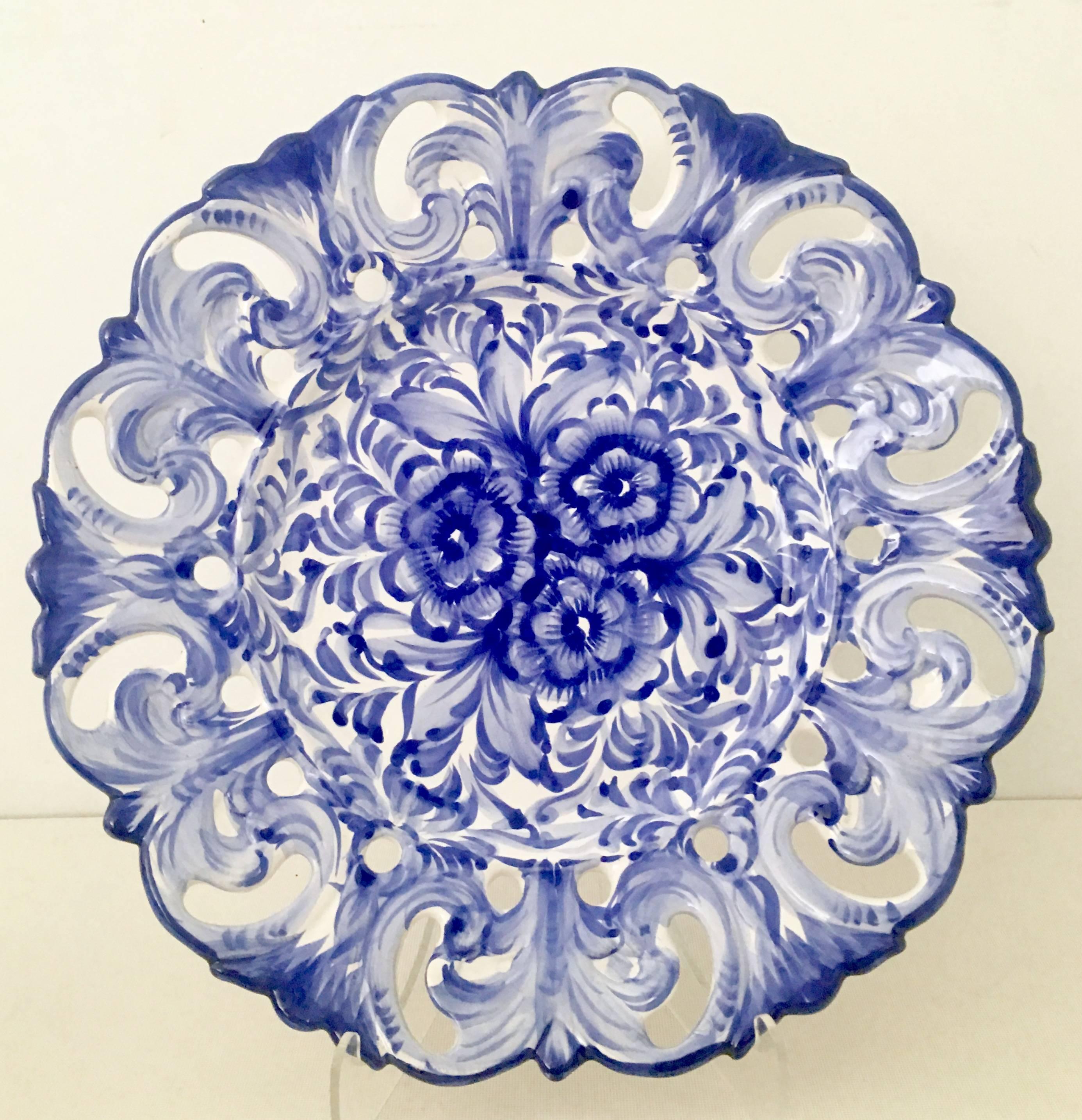 A rare set of five large Vestal Alcobaca hand-painted blue and white pottery hanging wall plates. These 13" inch round plates feature a blue and white floral motif, with a reticulated and scalloped edge. Each plate had existing wire for