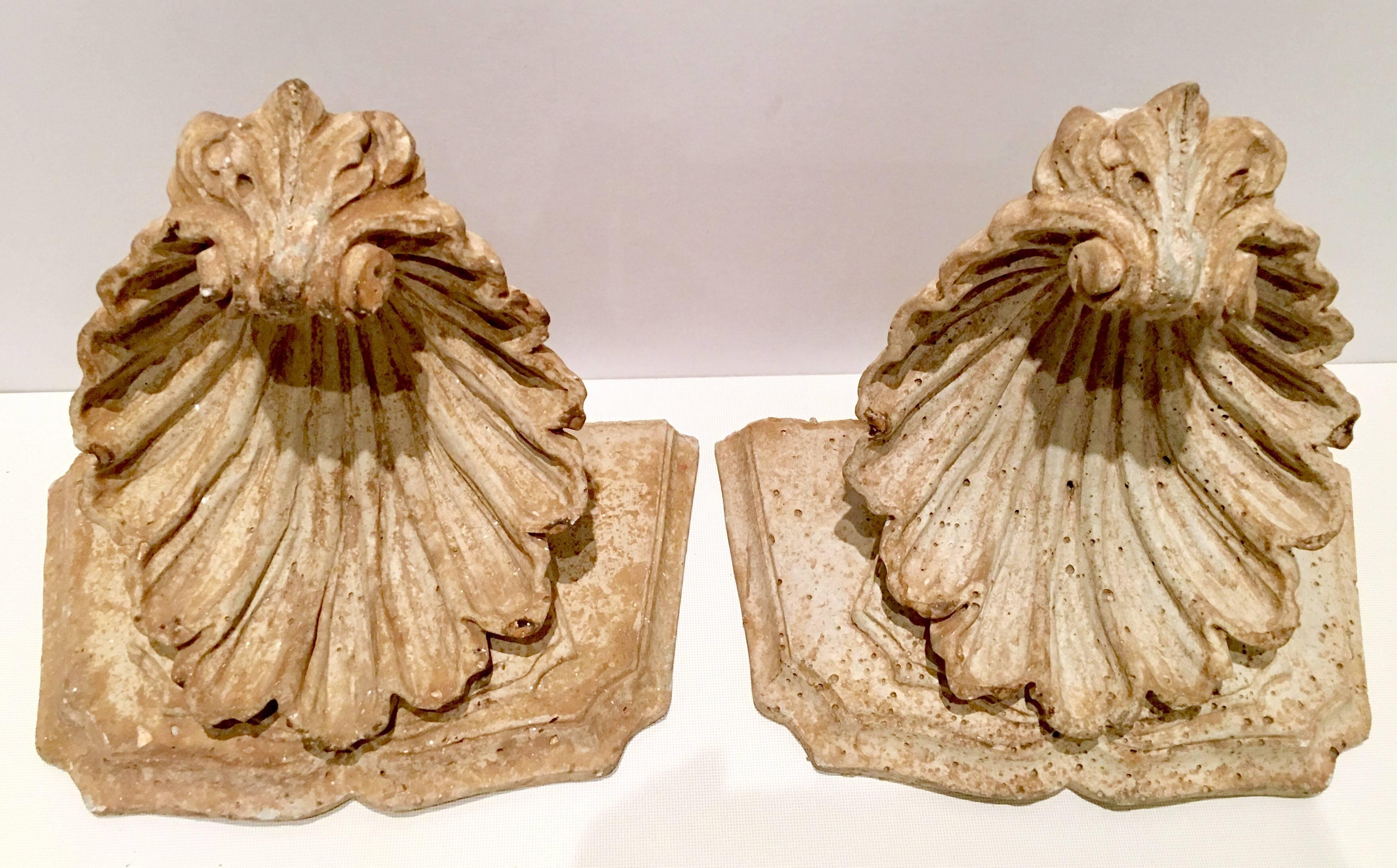 Classic 20th Century pair of cast stone scallop shell corbel/brackets. Procured from a Palm Beach estate, in magnificent pristine condition for their age. Each piece has ready to hang hardware installed.