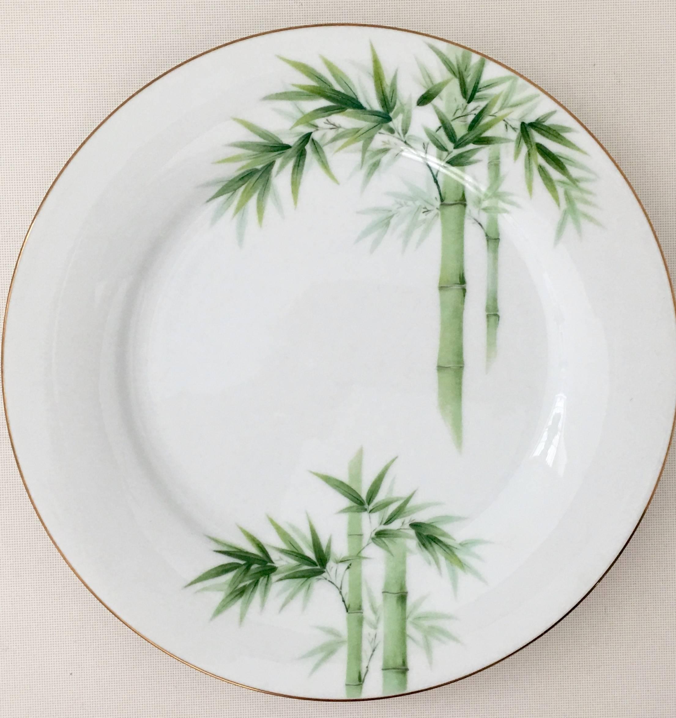 Vintage Japanese porcelain eighteen piece china set. This bright white ground pattern features a bright green bamboo pattern with a 22-karat gold rim detail. Set includes two dinner plates, eight bread/butter plates and eight fruit bowls. Each piece