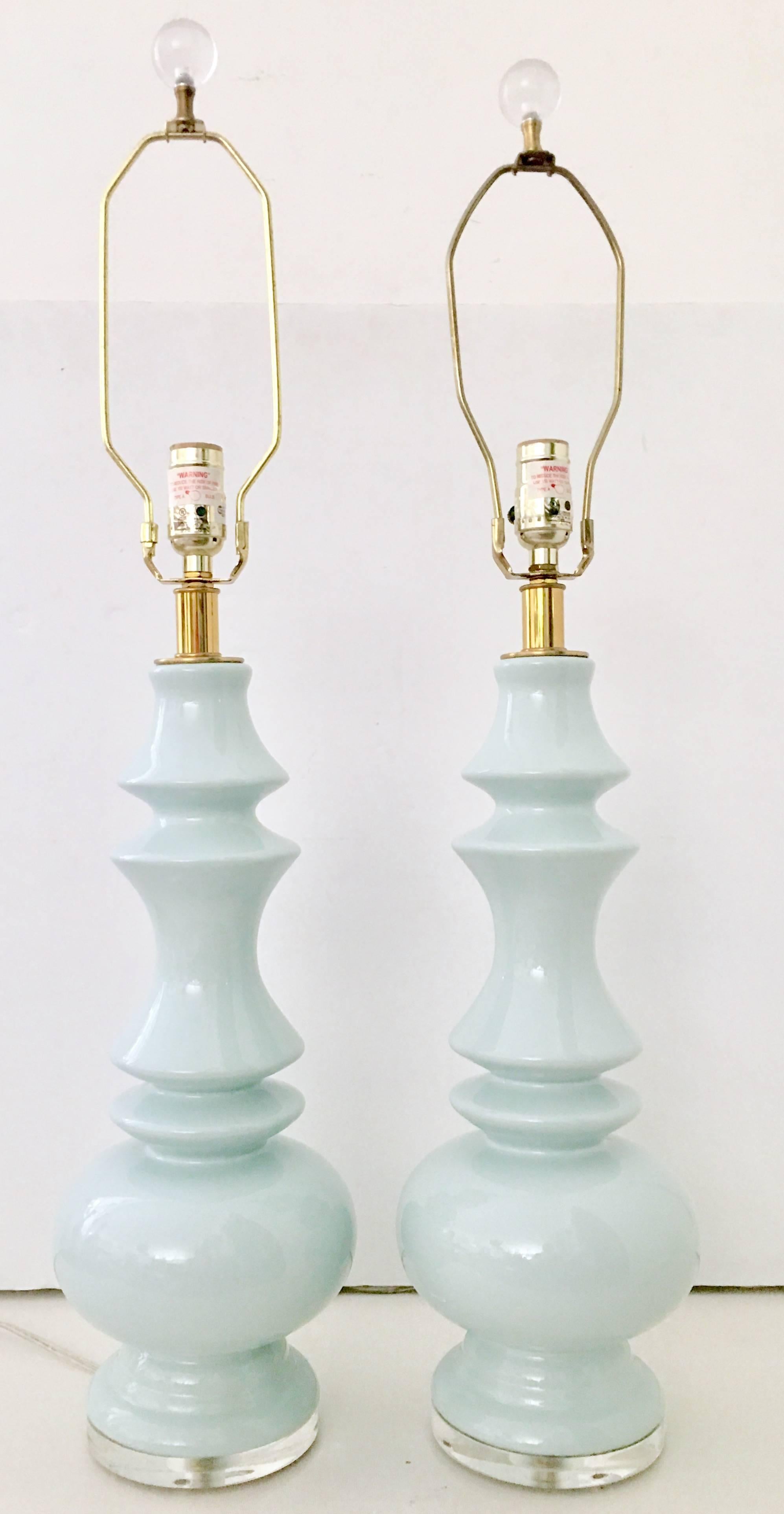 Pair of ceramic glaze robins egg blue "chess piece" form table lamps. Features a one inch Lucite base and brass fittings. Includes a pair of brass harps and Lucite round finials. Wired for the US and in working order.
Height to socket,