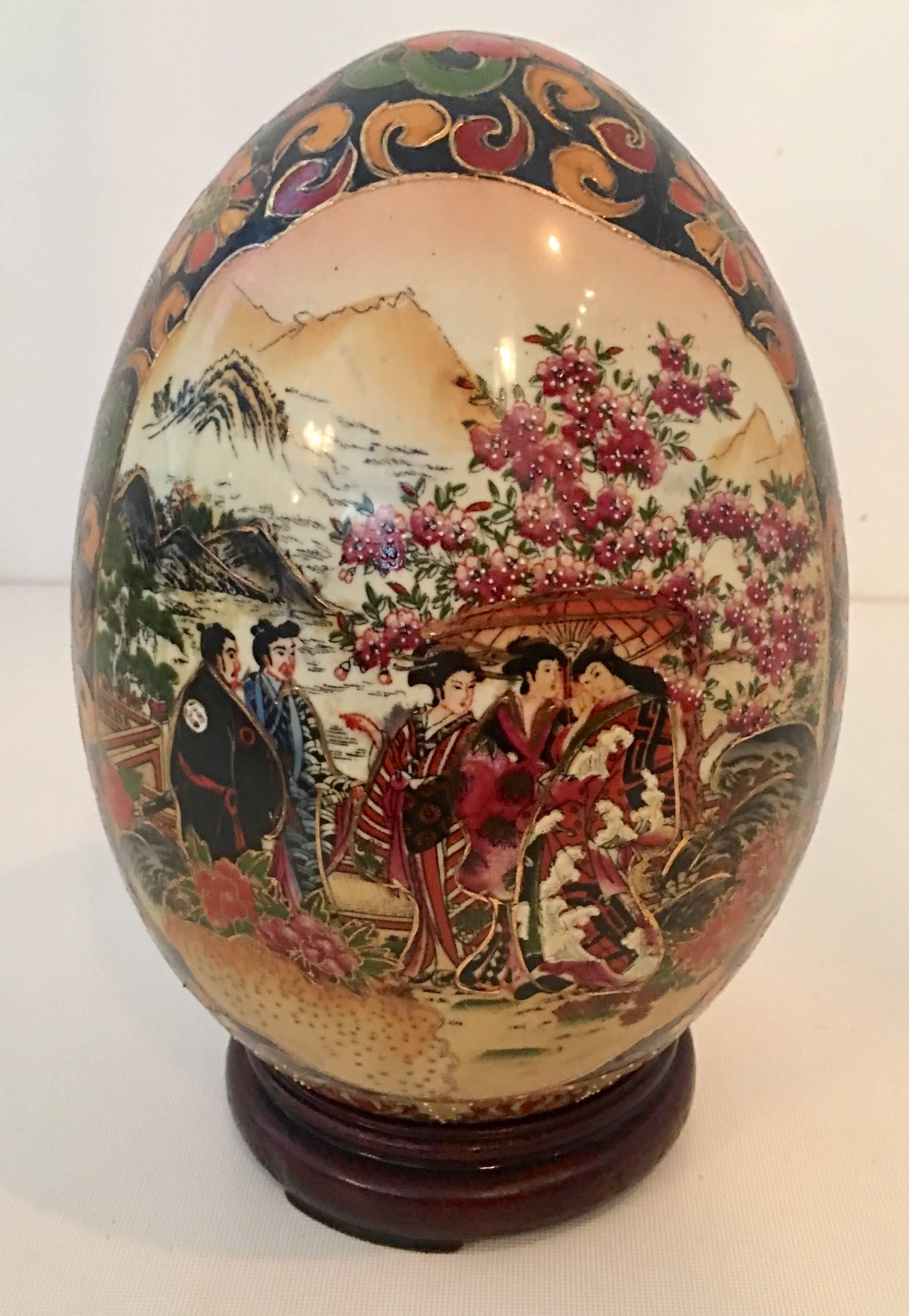 Antique Japanese goso blue hand-painted moriage 22-karat gold detail large egg sculpture on mahogany base.