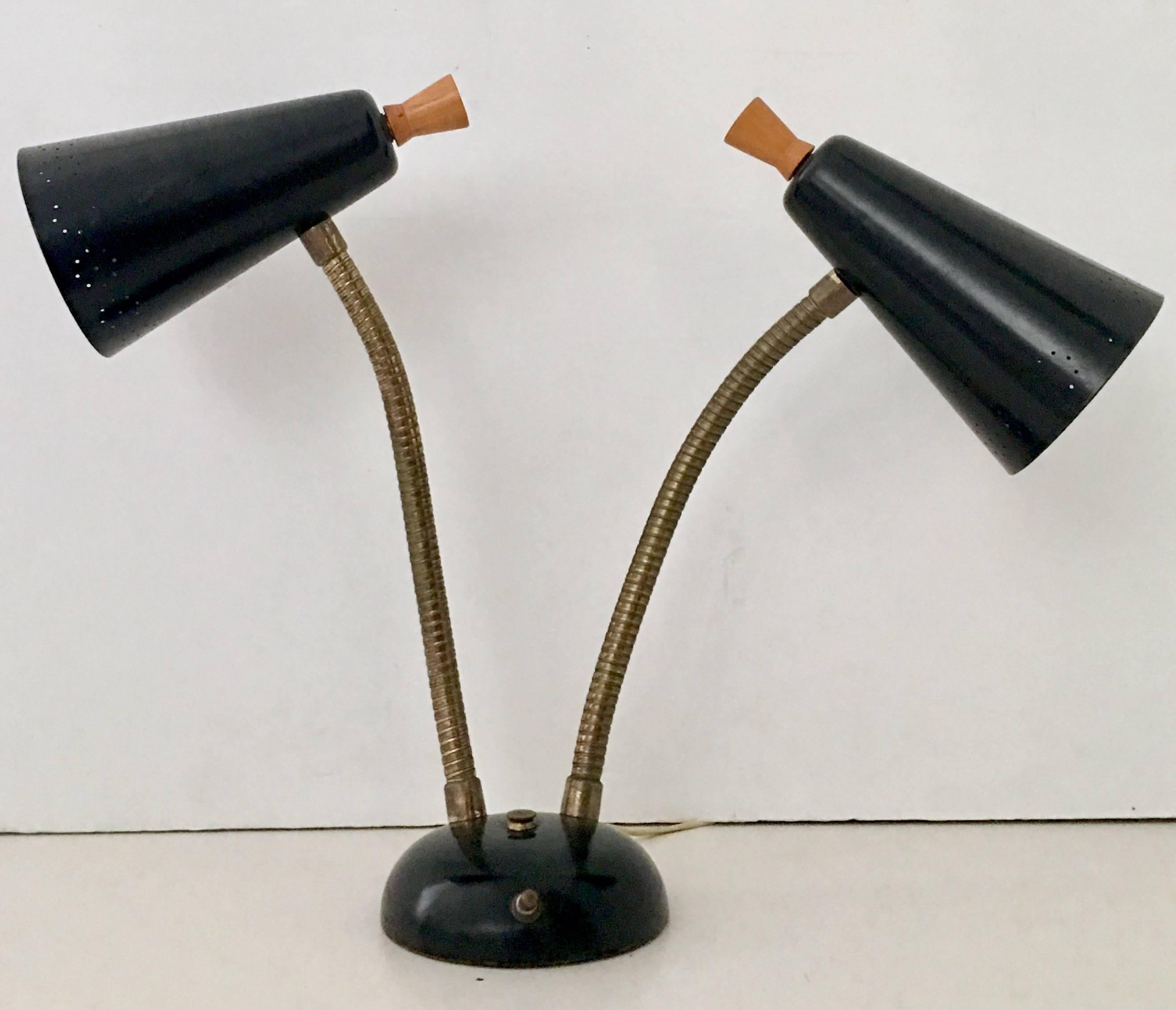 Mid-Century Modern Laurel style double two cone goose neck articulating table lamp. This iconic designed Mid-Century Modern task lamp is fabricated of black enameled metal with two perforated cones, brass fittings and walnut wood knob detail. The