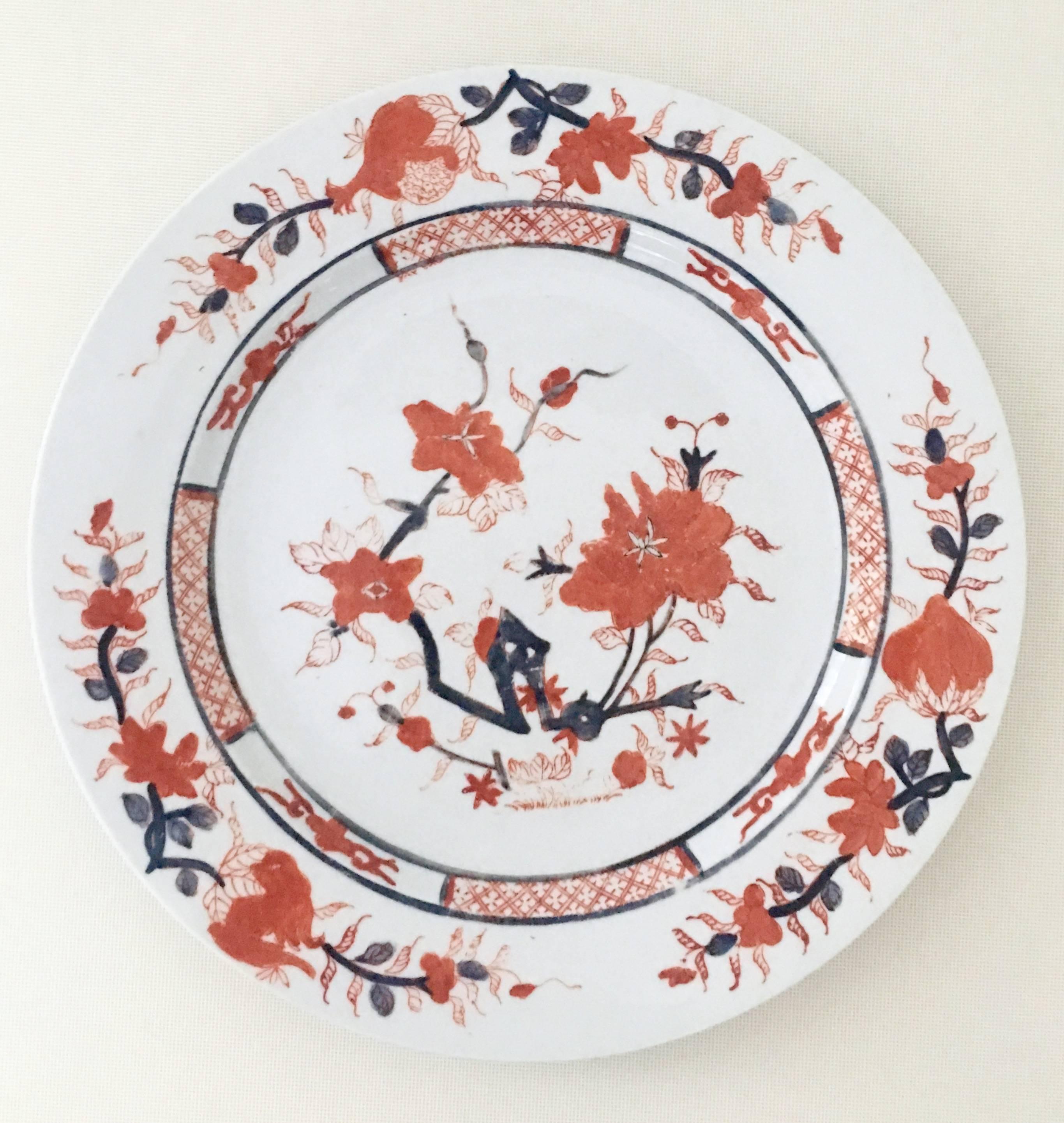 20th Century Japanese Imari porcelain dinnerware, six-three-piece place settings. Features a white ground with 22 karat gold hand-painted and enameled ink blue and red to orange hues. Each piece is marked on the underside, decorated in Hong