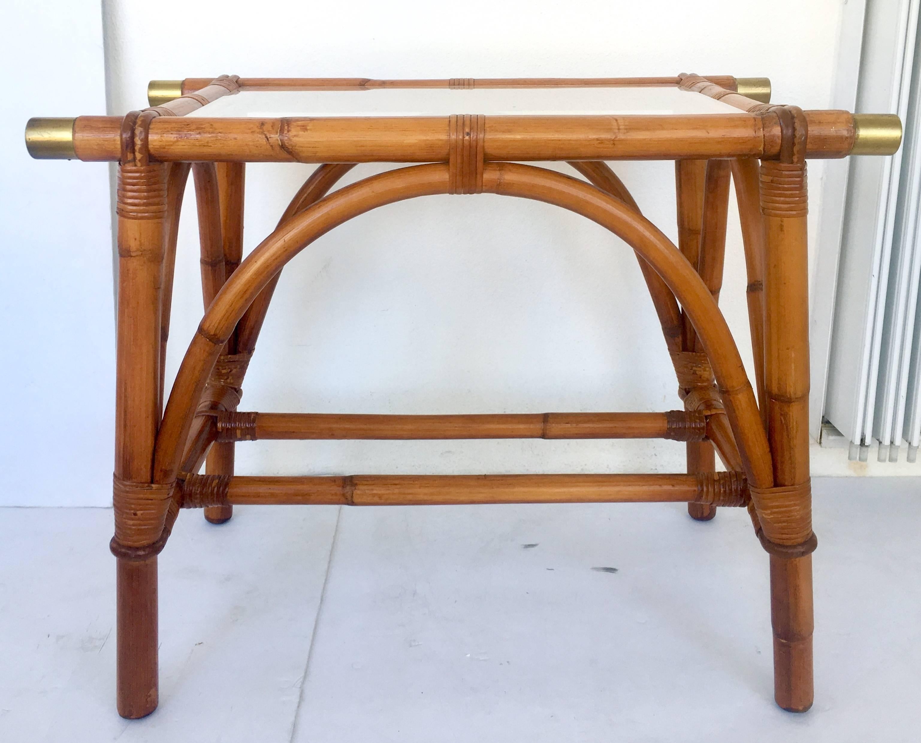 Mid-Century Campaign style rattan glass top side or end table with brass ferrule end caps by Ficks Reed. Features leather straps.