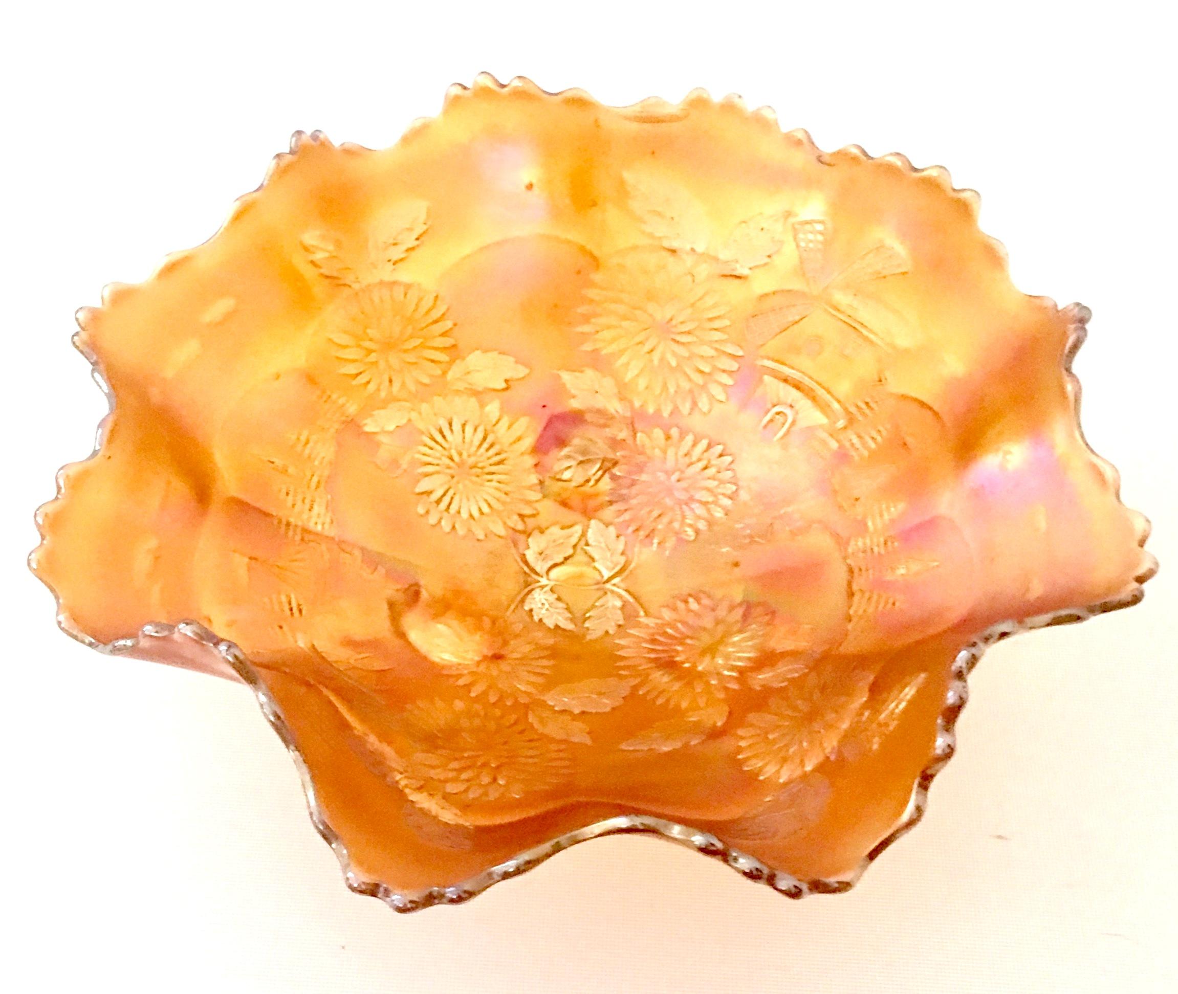 1930s American Art Glass iridescent Marigold Windmill Ruffle bowl by, Fenton. Features a lovely orange with pink iridescence shimmer, raised windmill, sail boat and chrysanthemum motif with three scroll and ball feet.
The Fenton Glass Pontil mark
