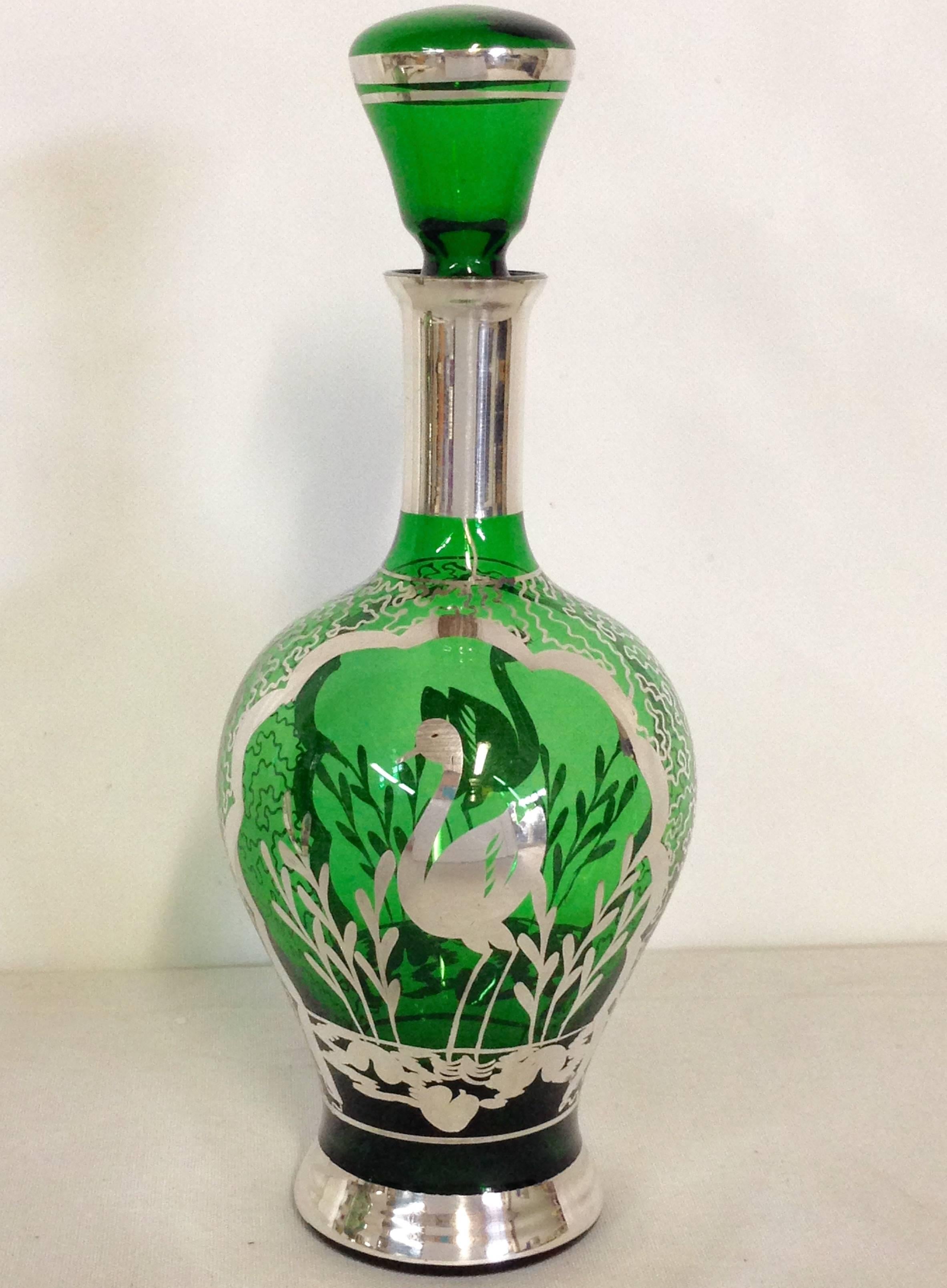 Unique pair of emerald and heavy sterling silver-overlay decanters with ornate grassy water and crane motif.