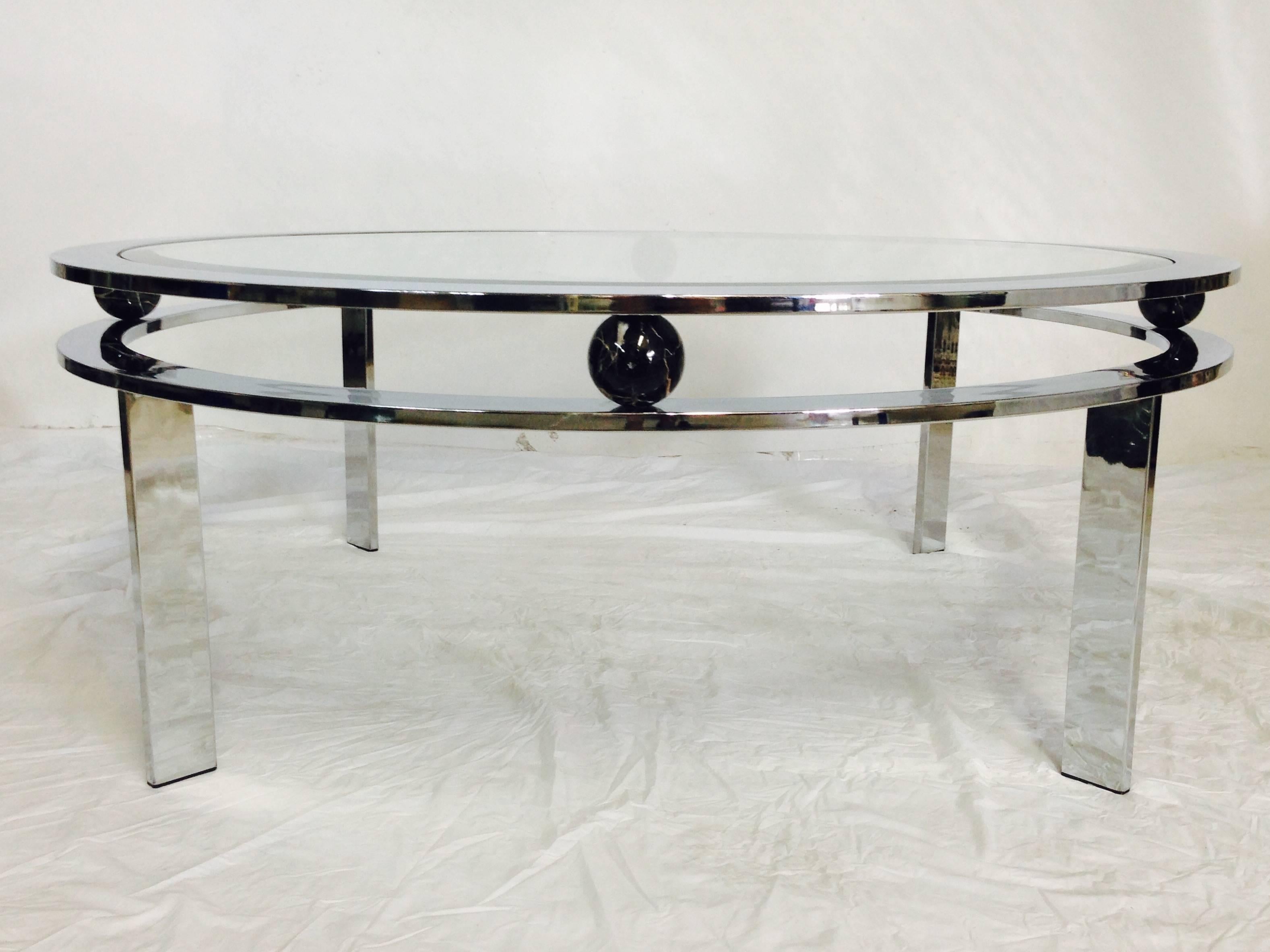 Design Institute of America round chrome coffee table with glass top. Decorated with two round black with white veined marble balls. Signed and numbered "D.I.A. 133966" on the underside. Original metal manufacture's label intact.
