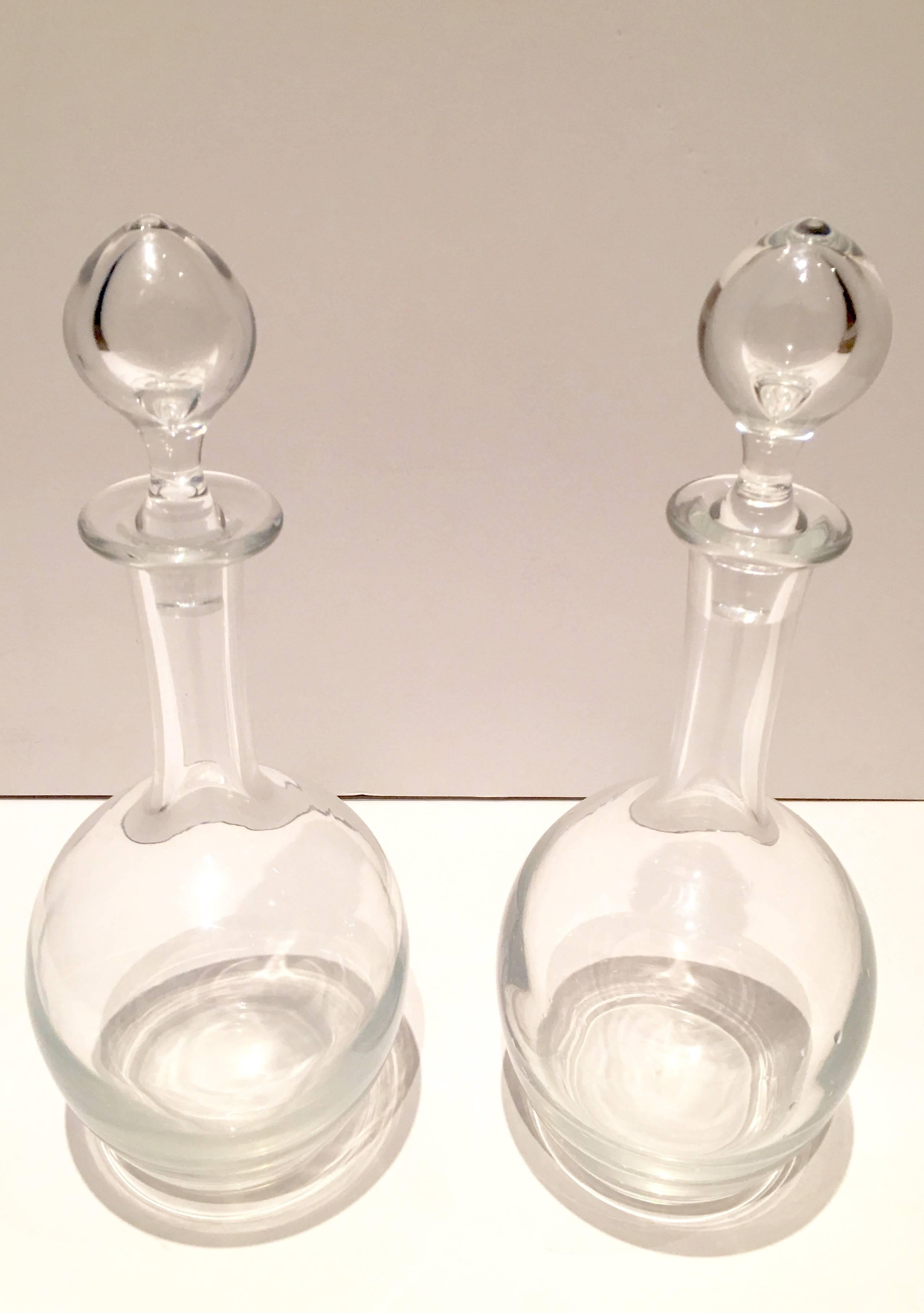 This pair of crystal clear decanters with stoppers are each marked on the underside, Baccarat, France.