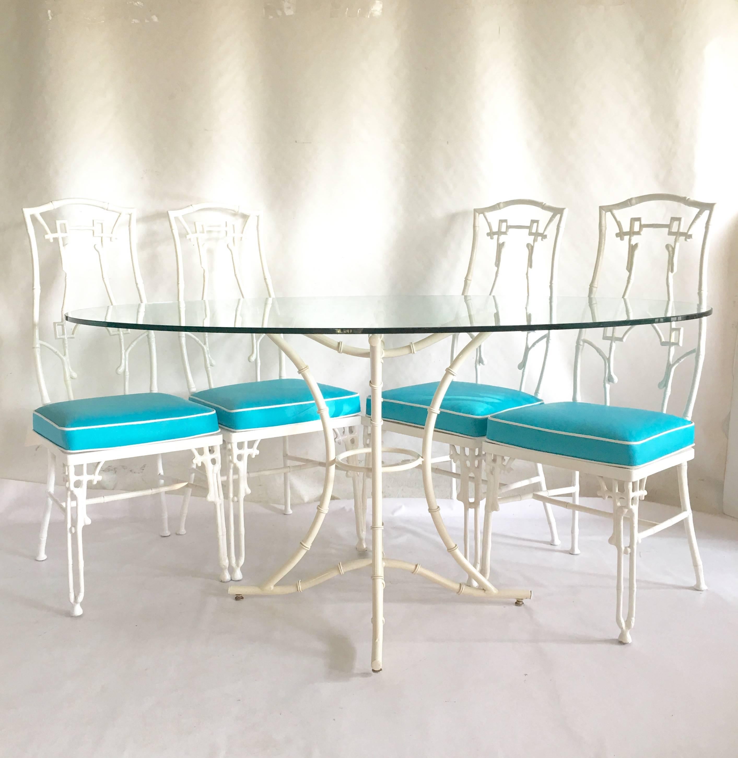 Hollywood Regency six-piece faux bamboo chairs and table. Newly upholstered seats in bright aqua marine vinyl with a bright white vinyl welt. Oval 1/4 inch thick glass top. Chairs measure, 36.5 in height and 18.5 deep. Seat height is 18