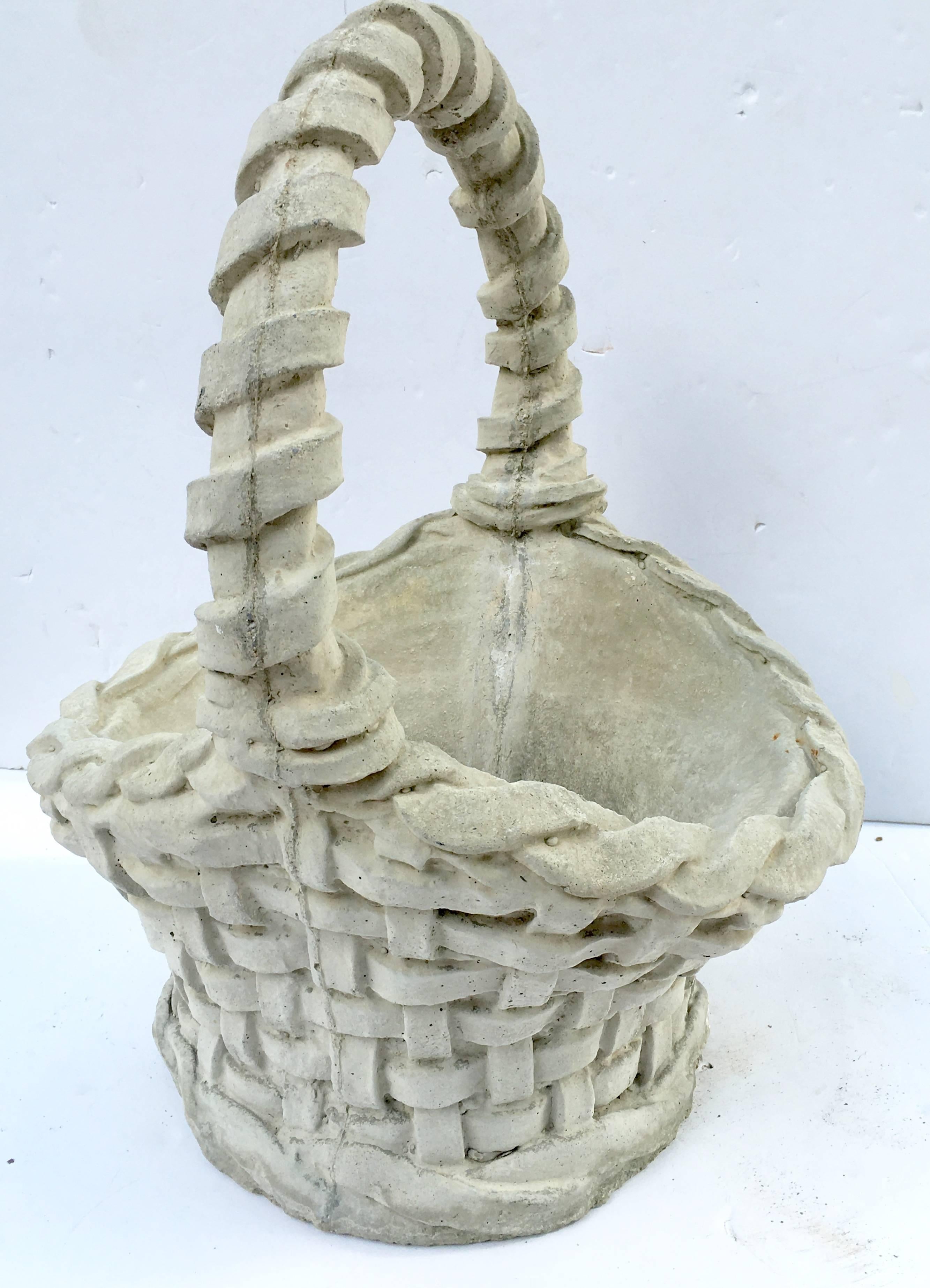 A rare pair of  vintage American made painted concrete basket weave twisted handle basket planters. Each basket is signed and numbered in the interior of the basket.