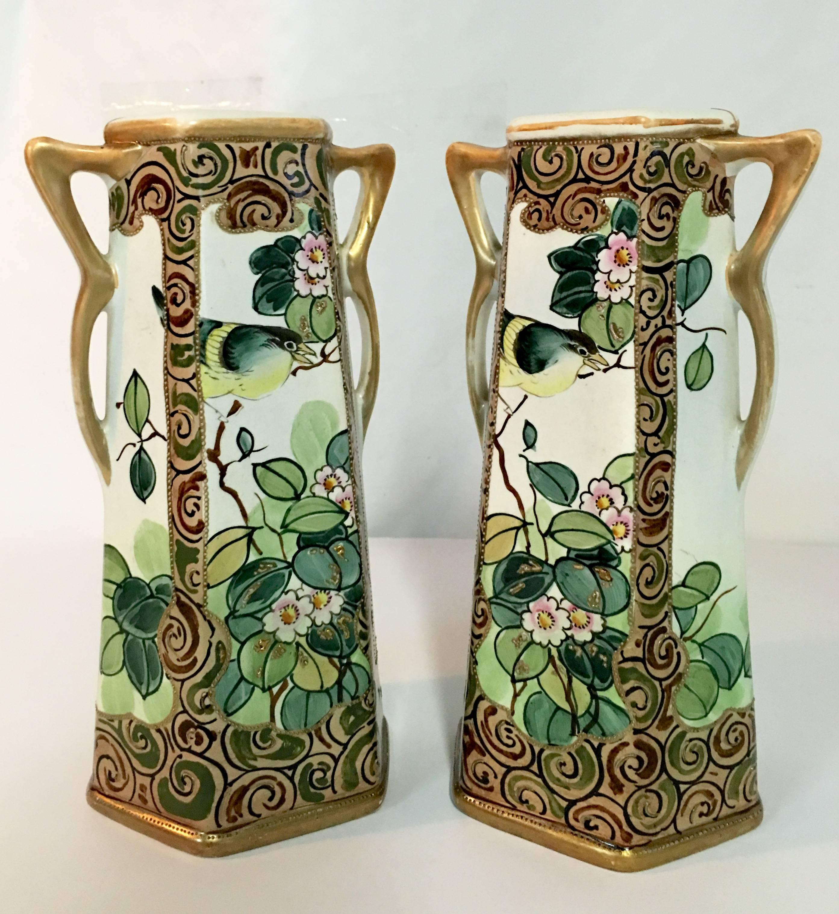 Rare pair of white ground with browns, greens, yellow, pinks and 22-karat gold moriage and trim detail identical five-panel double handle porcelain vases, 1920s. Each vase is signed on the underside hand-painted Royal Nishiki Nippon.