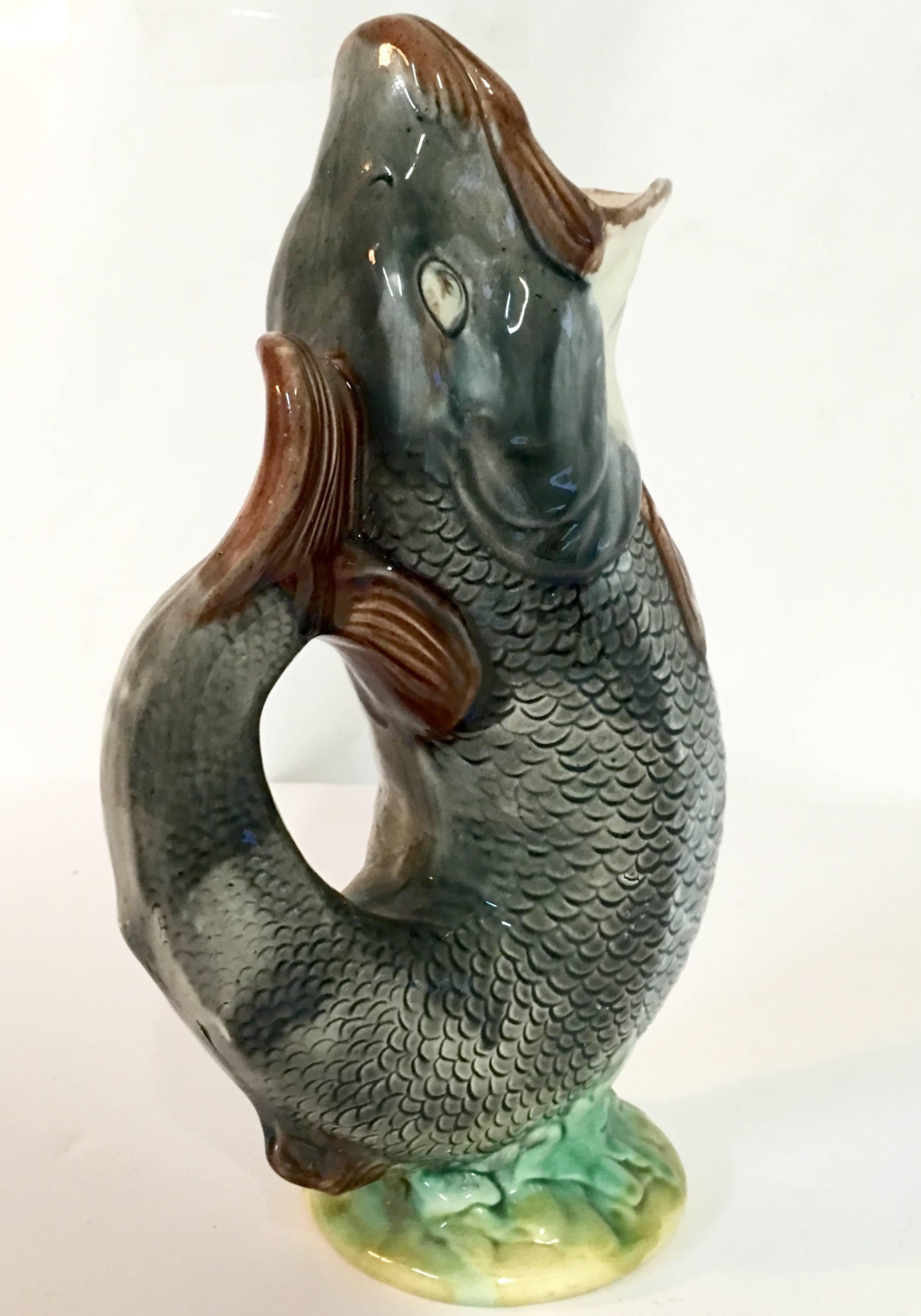 Late 19th century antique majolica gurgling fish serving pitcher. This rare charcoal scales and pink throat with multi green base colored pitcher is in pristine condition for its age. Signed on underside.
