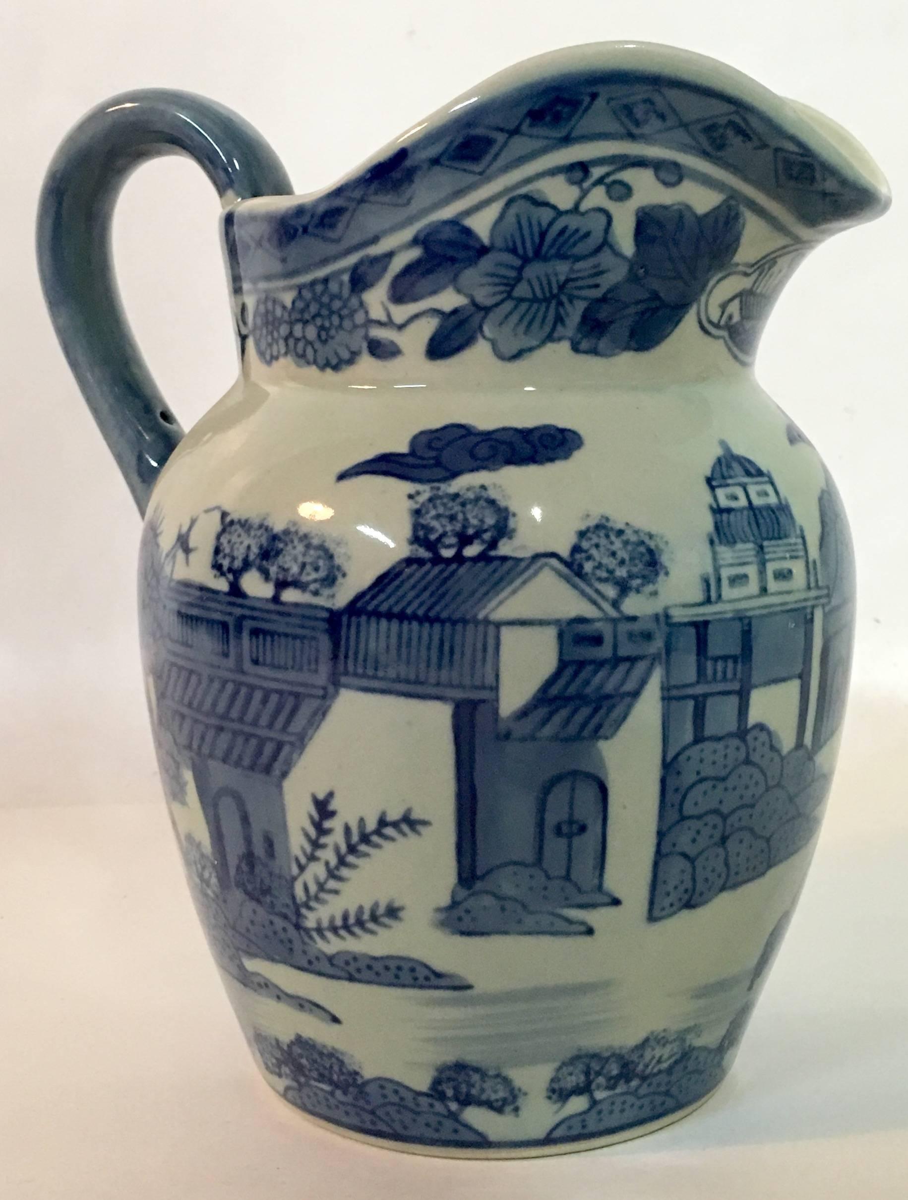 Antique blue and white handled beverage pitcher village scene. Blue handle detail. Mark appears on underside.