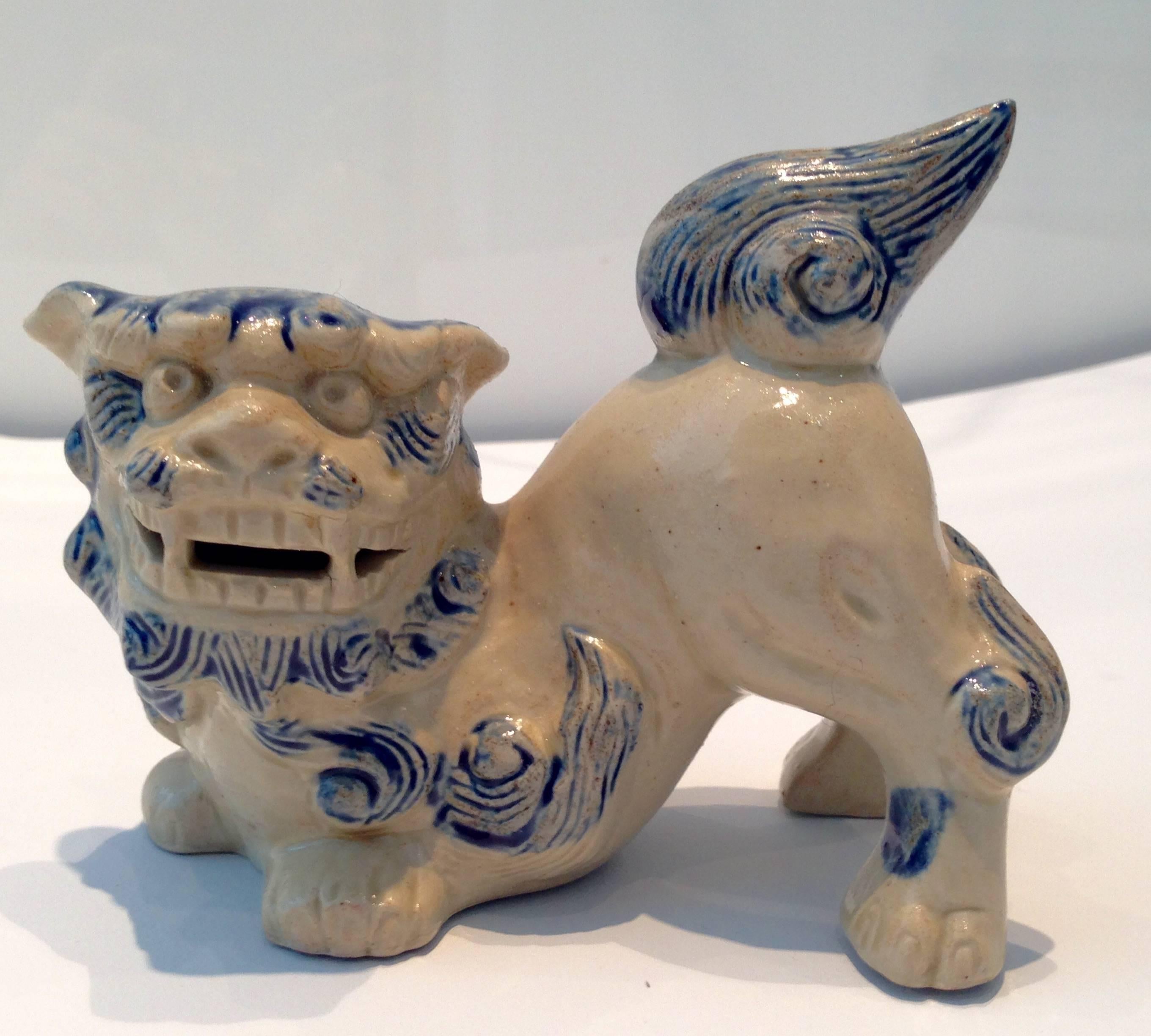 Early pair of miniature glazed ceramic foo dogs in beige and blue. Used to guard the entryway to temples and homes of the very rich, they depict the guardian lions of the Far East. Always in pairs to represent classical Feng Shui yin and yang, they