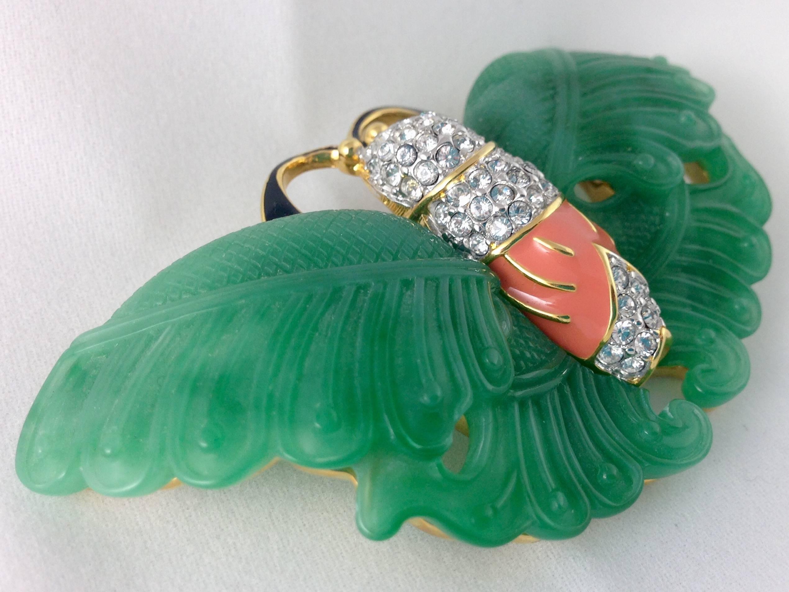 Very rare Kenneth J Lane collectible butterfly brooch with faux-jade, coral and crystal clear rhinestone embellishments. Set in gold plate and signed on the underside KJL.
This coveted brooch is a book piece which can be found featured in Nancy