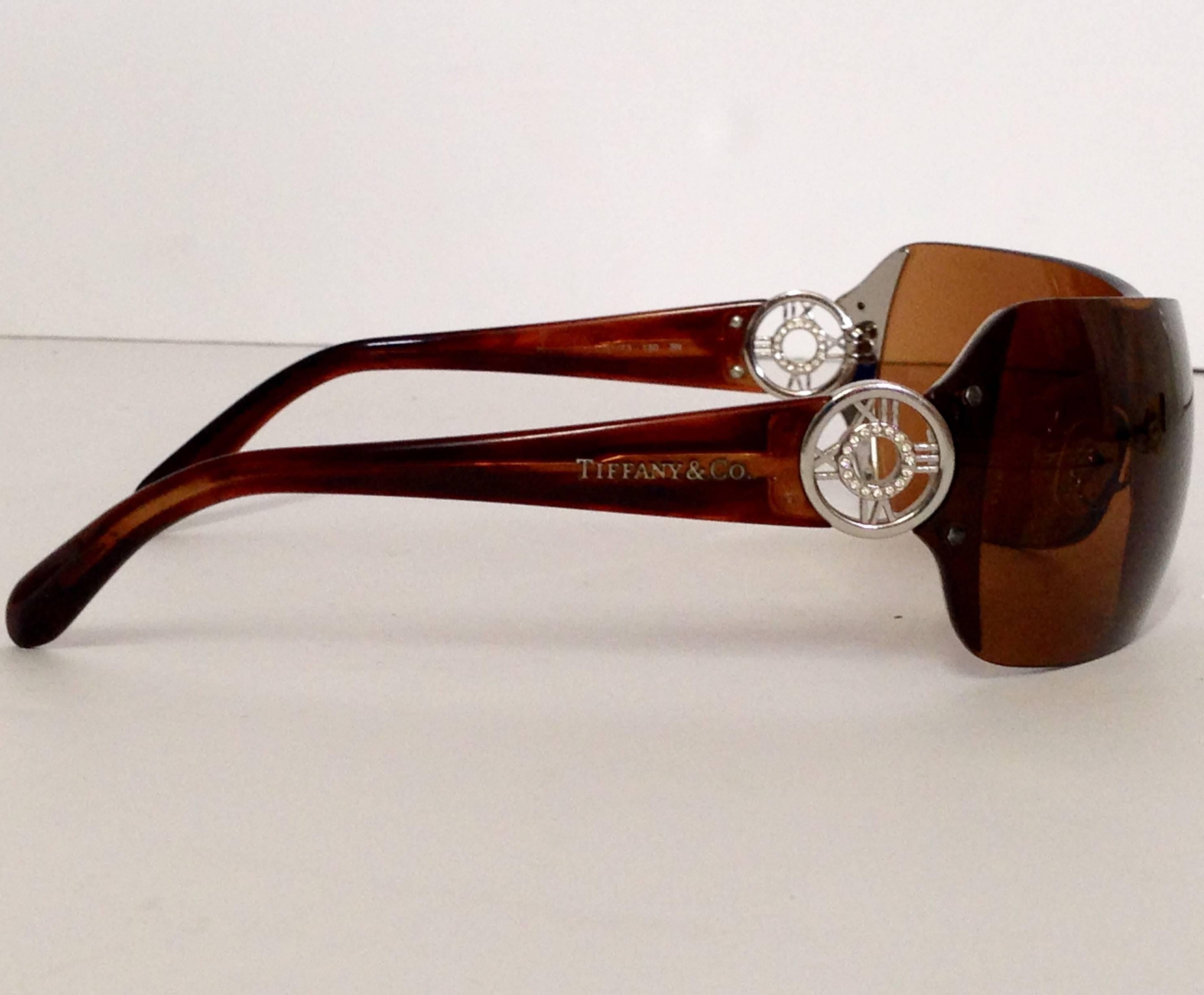 Rare vintage Tiffany & Co. iconic Roman numeral logo tinted sunglasses. The silver tone round roman numeral detail at the temples are embellished with clear crystal Swarovski rhinestones. Signed left front lens T & Co. Model or production