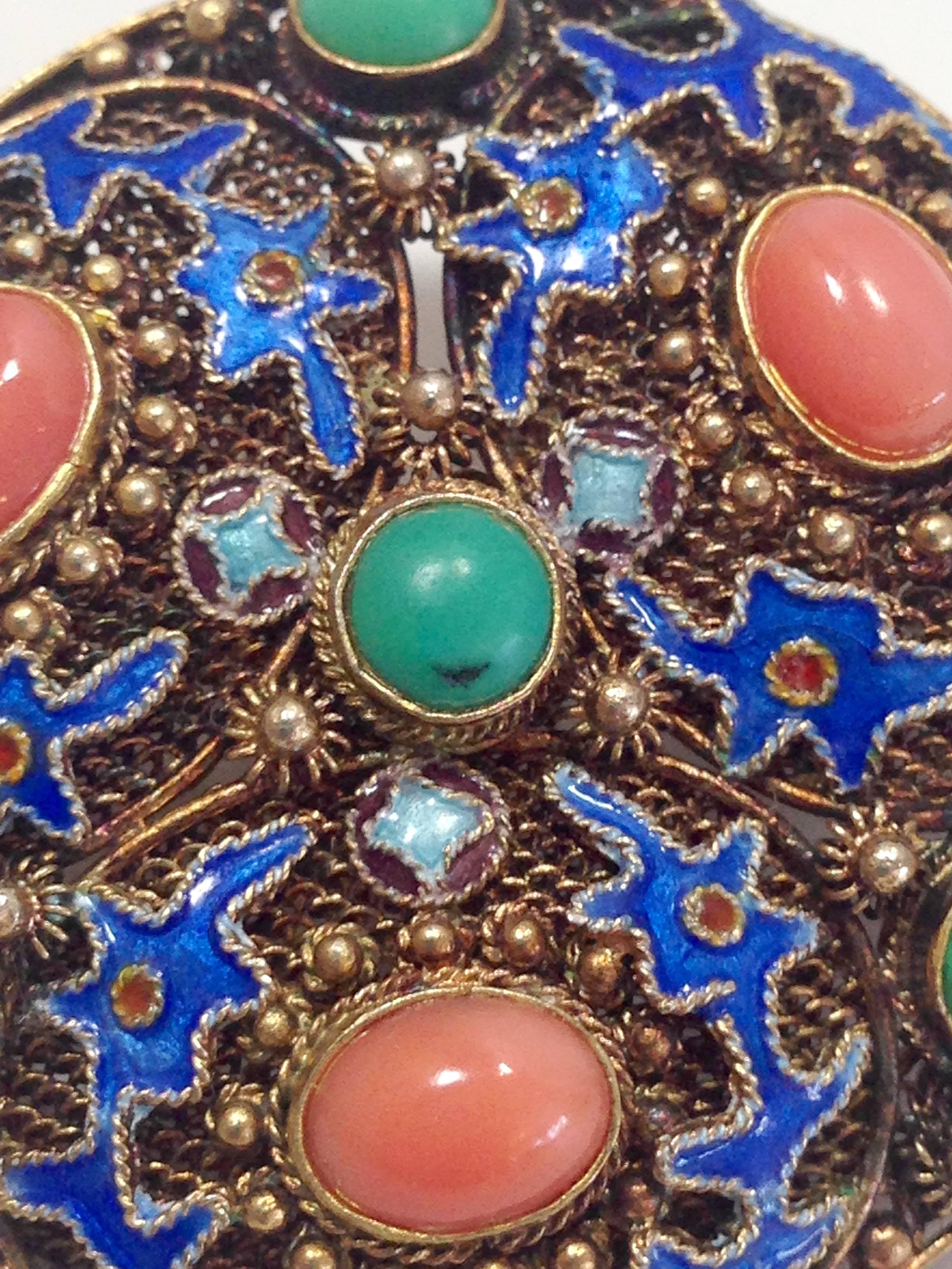 Extremely rare and coveted vintage Chinese brooch with 22-karat gold vermeil over 925 silver base. Three oval cabochon set coral stones and four round turquoise stones with cobalt blue enamel abstract dragon figure cloisonne work. Raised gold dot