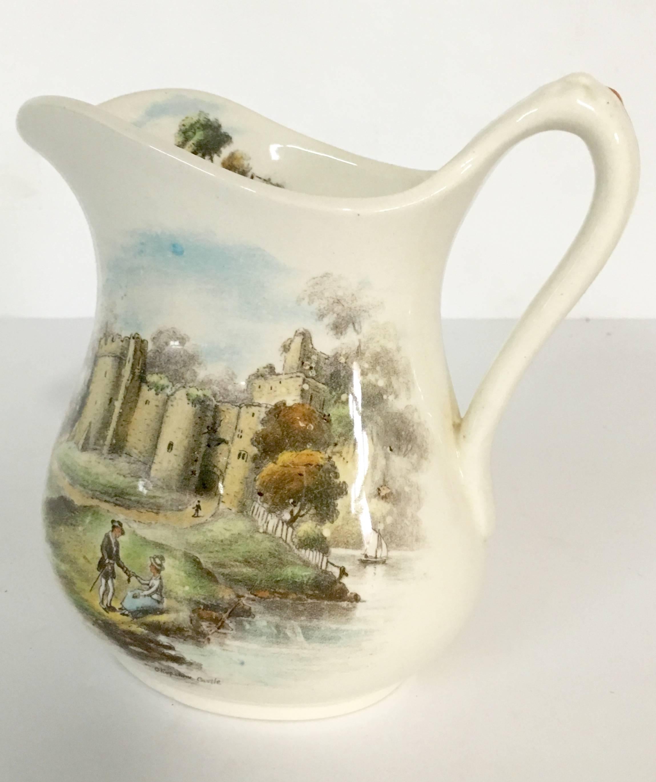 Antique English-made, glazed, ceramic pitcher depicting a couple in the foreground of a castle. Two-sided pattern placement, signed 