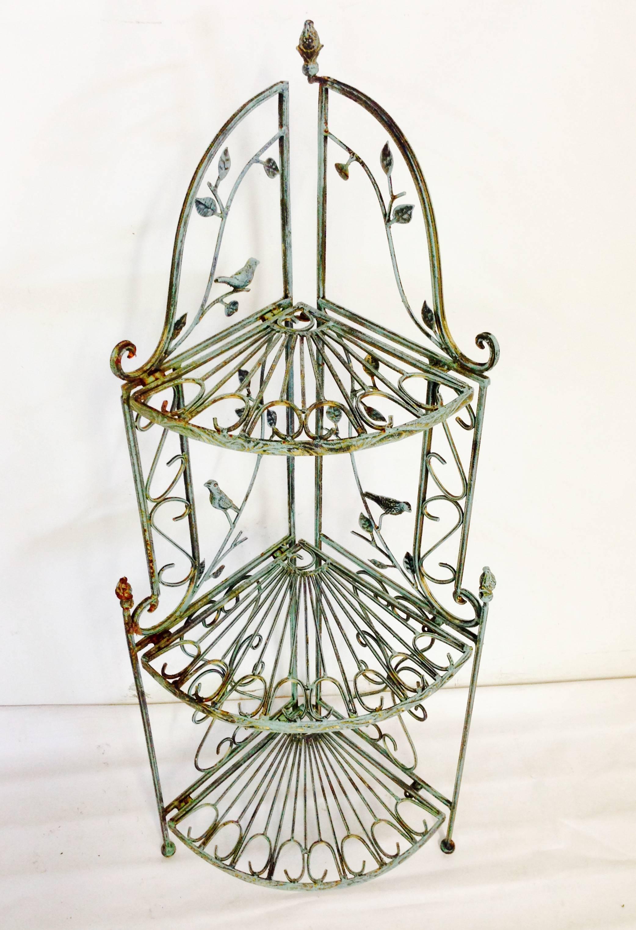 This adorable bird motif collapsible and adjustable three-tier shelf is iron painted in a verdigris green finish. Scroll and branch detail, each shelf is a different dimension and curved to fit in a corner and or float. Can be used indoors or
