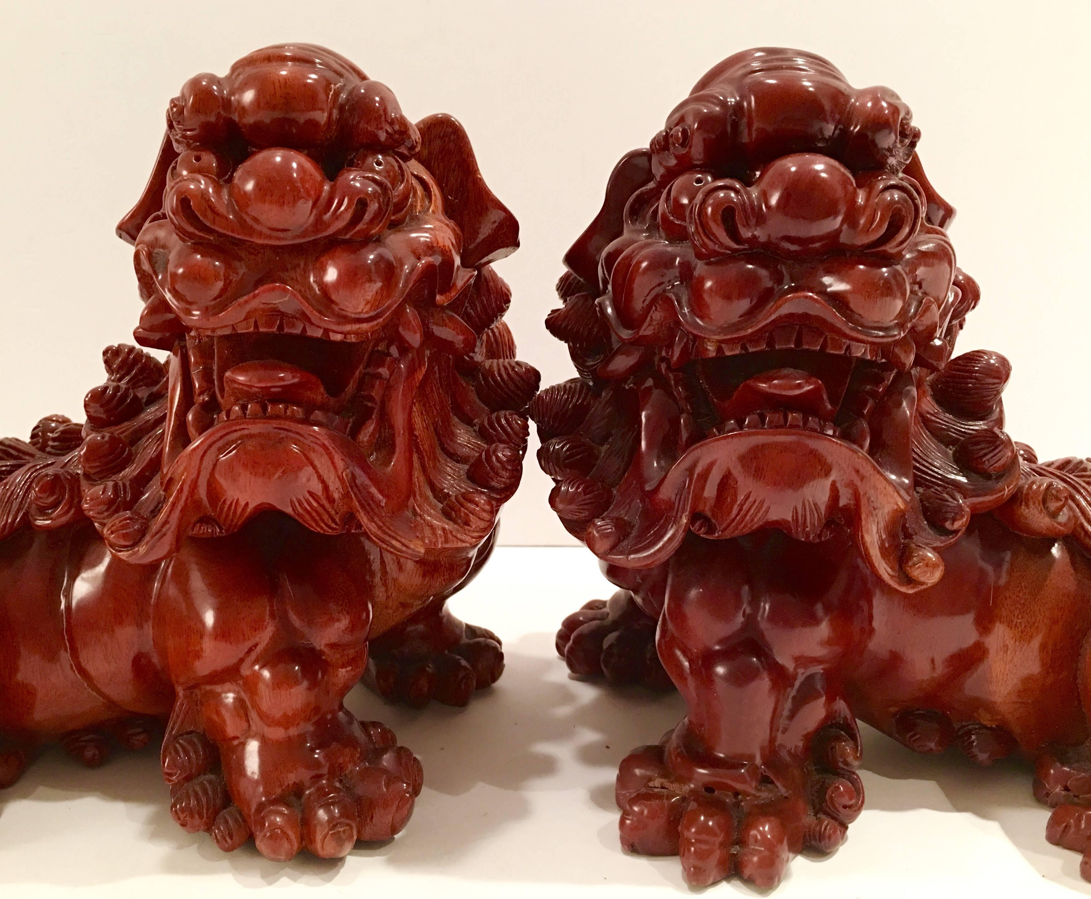Large pair of antique hand-carved wood foo dogs. Incredible artisan craftsmanship with great attention to detail. High gloss clear lacquer finish.