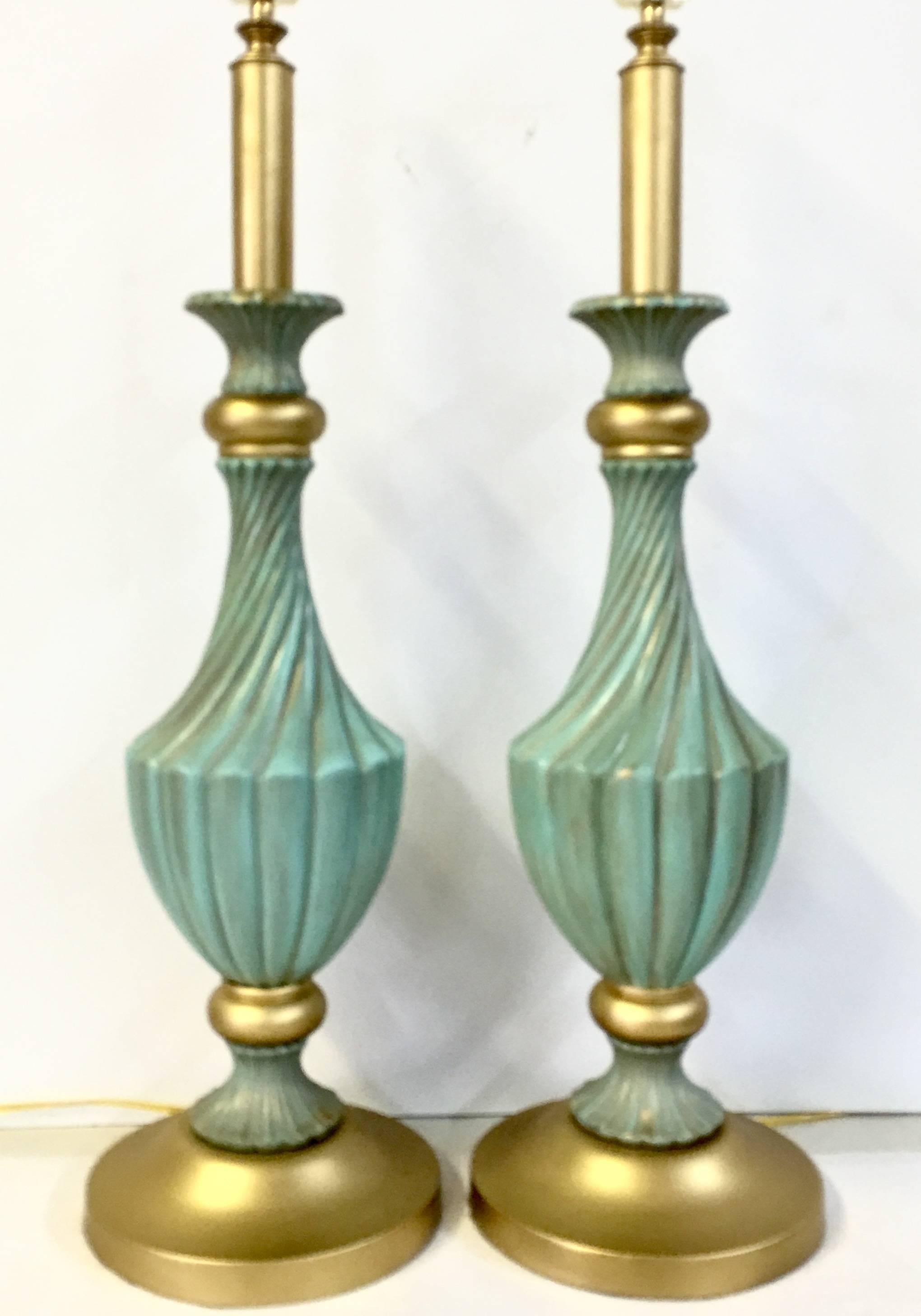 Pair of Stiffel style ceramic and brass painted gold gilt lamps. Neoclassical style twist body in aqua with gold fleck detail throughout. The brass fittings have been newly painted in gold gilt metallic, including the bases. Wired for the US, in