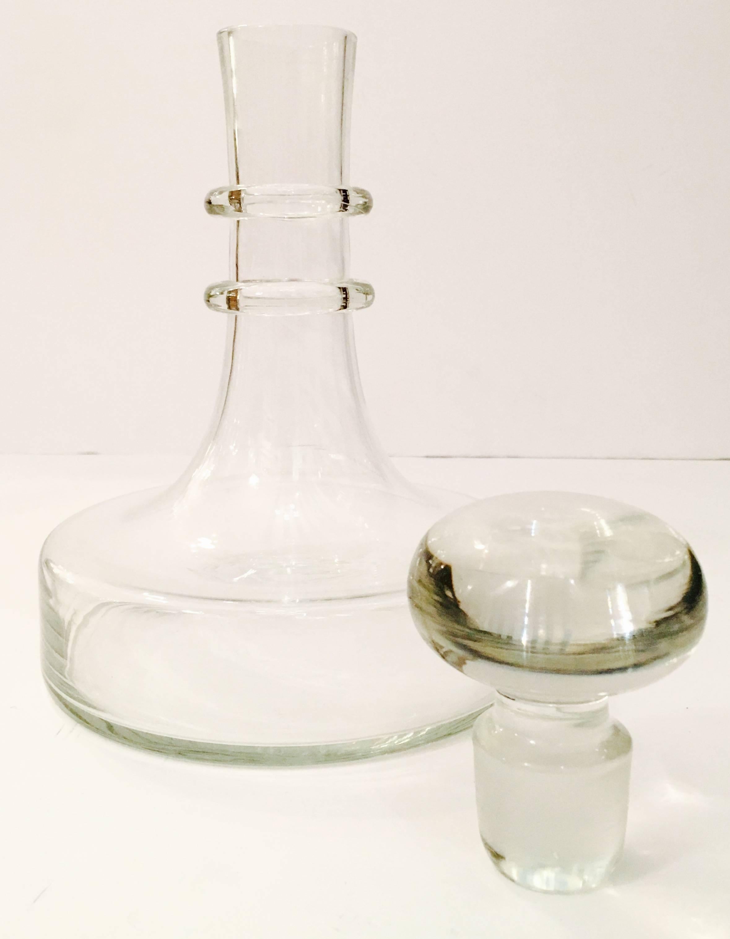Mid-Century Modern crystal clear decanter with stopper. Clean lines with a two ring detail make this decanter the perfect addition to any collection.
