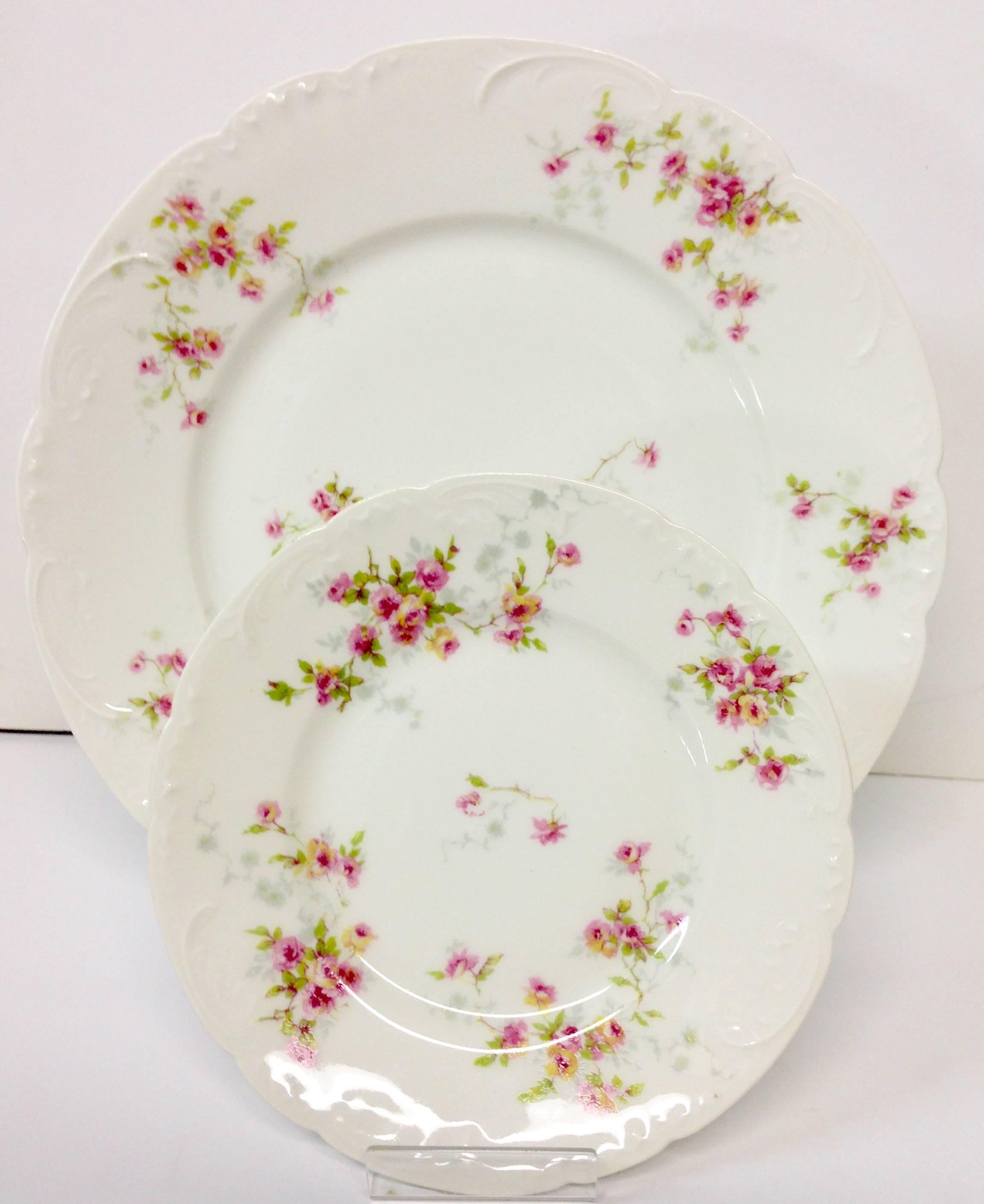Early 20th century Limoge hand-painted porcelain pink roses motif plate set of 12. Set includes, eight dinner plates and four bread plates, 6.25