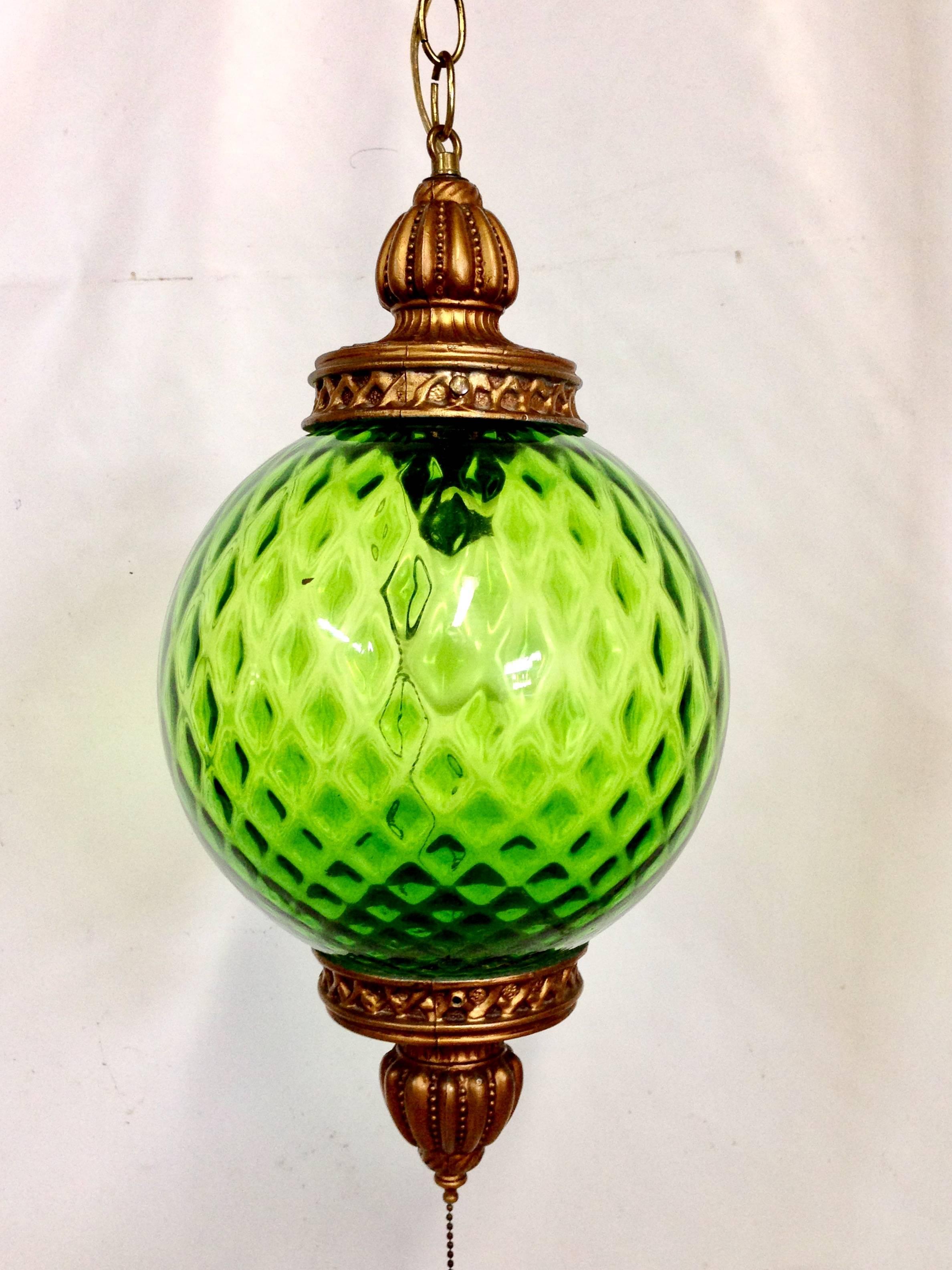 Stunning and vibrant apple green optic blown glass sphere hanging pendant light from Italy. Antiqued brass metal detail.
Details:
Green globe: 10" inches diameter, 19" inches from top of brass to bottom of brass base of globe.
Pull chain