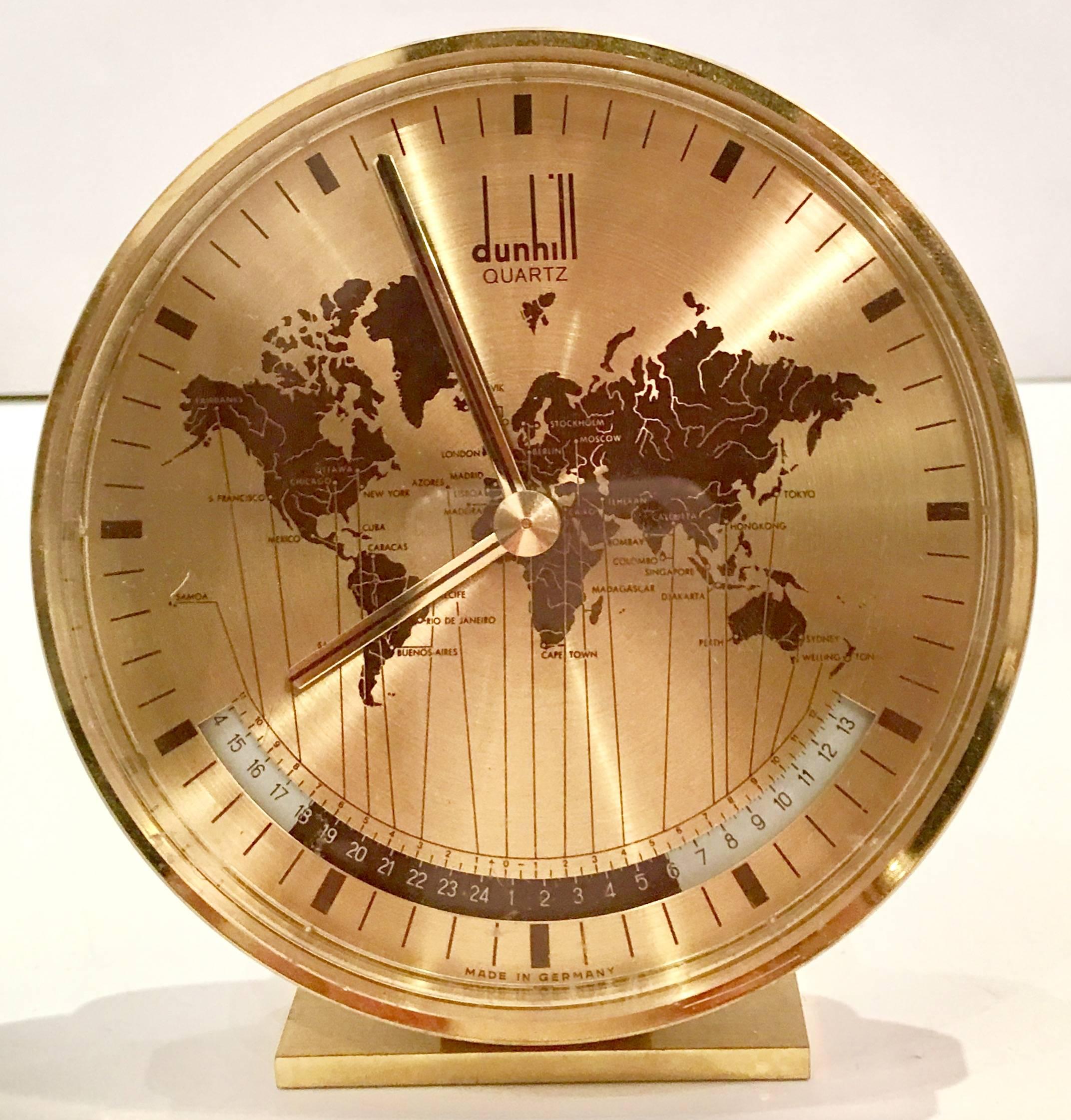 Alfred Dunhill world quartz desk clock by Kienzle, Germany. Features gold brass frame and stand, Lucite shadow box style front cover and gold and brown face and dial. Dunhill logo on front as well as made in Germany lower front center. The back is