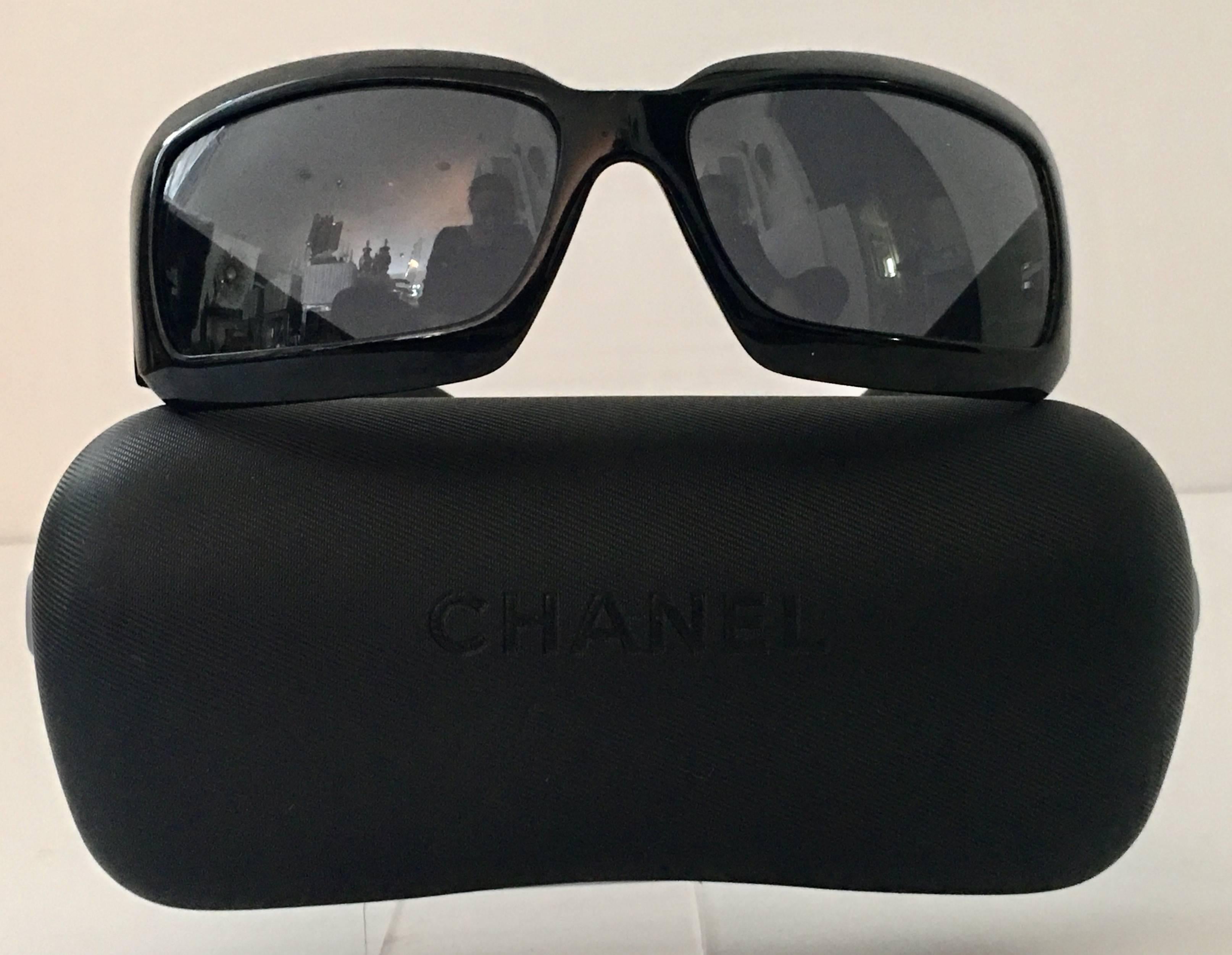 Classic Chanel black with white mother-of-pearl inlay "CC" logo sunglasses. Right side of right lens is signed Chanel. Interior arms read, 5076-Chanel Made In Italy. Includes Chanel hard protective storage case.