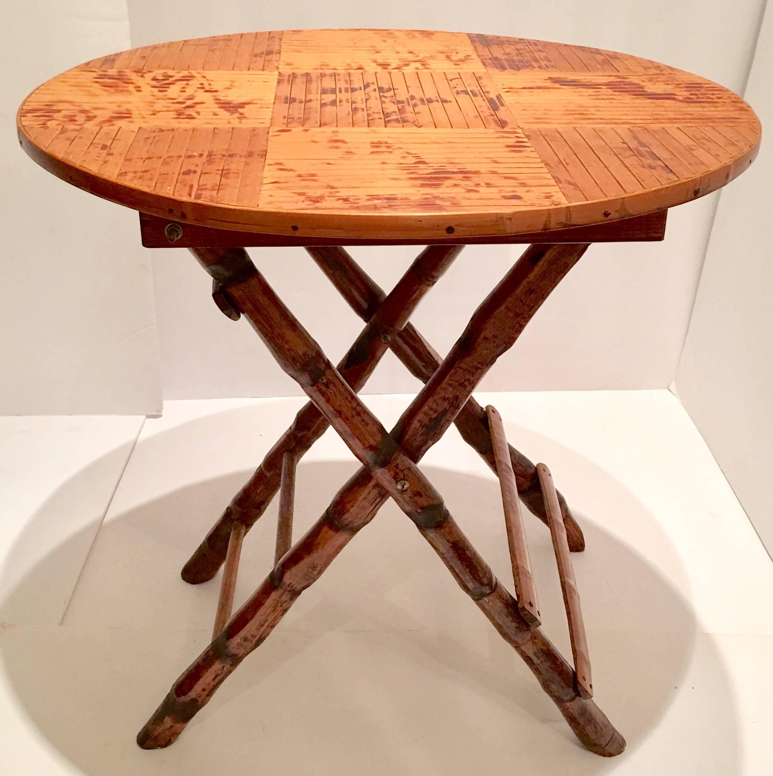 Rare Mid-Century Campaign style folding table in "burnt" bamboo and rattan. This table has a wood top wrapped in rattan and the top measures, .50