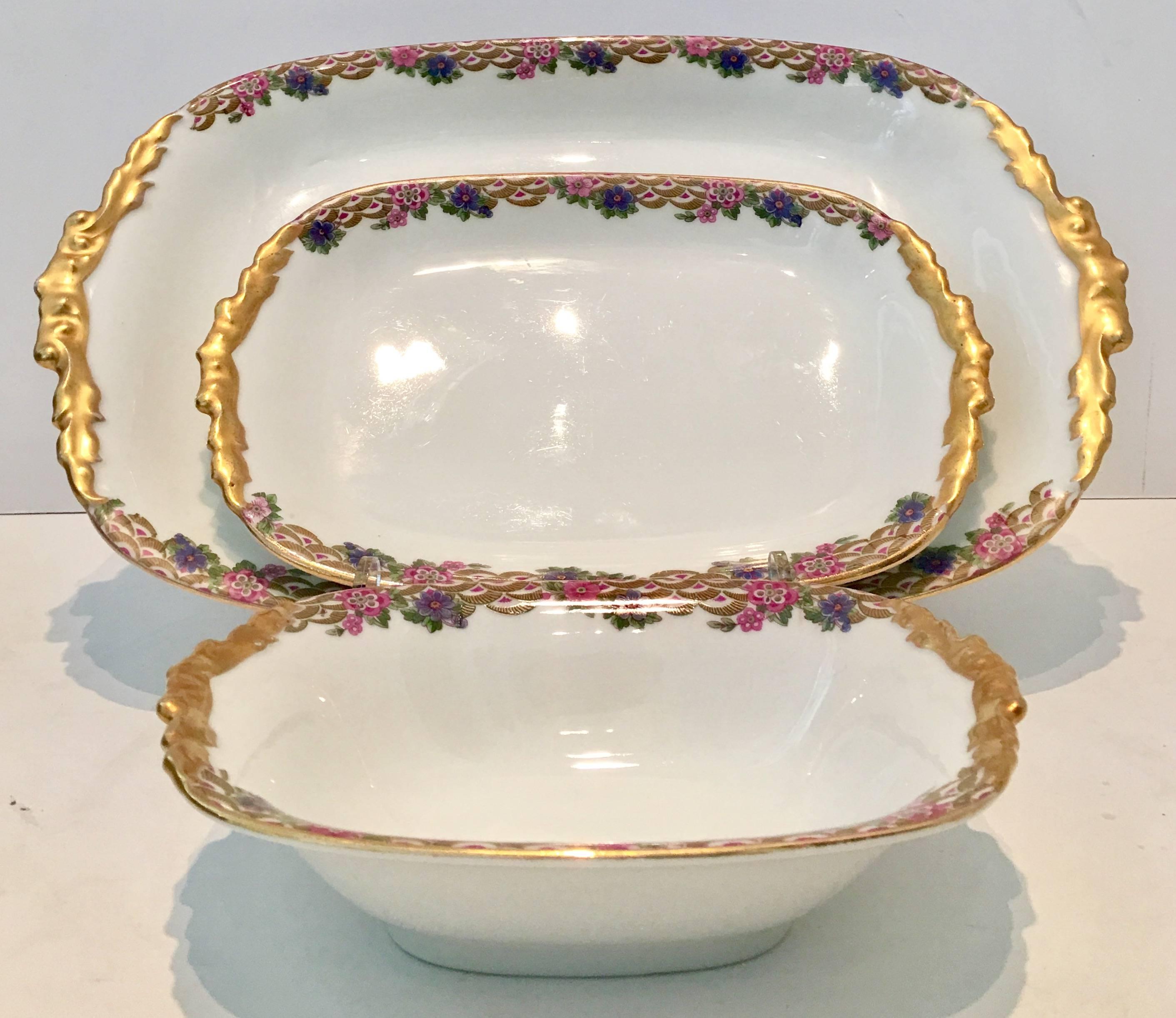 Early 20th century Art Deco French Limoge hand-painted Porcelain by, Jean Pouyat dinnerware set of three serving pieces. This Art Deco pattern features a bright white ground and purple, pink, chartreuse and green geometric floral pattern edge and
