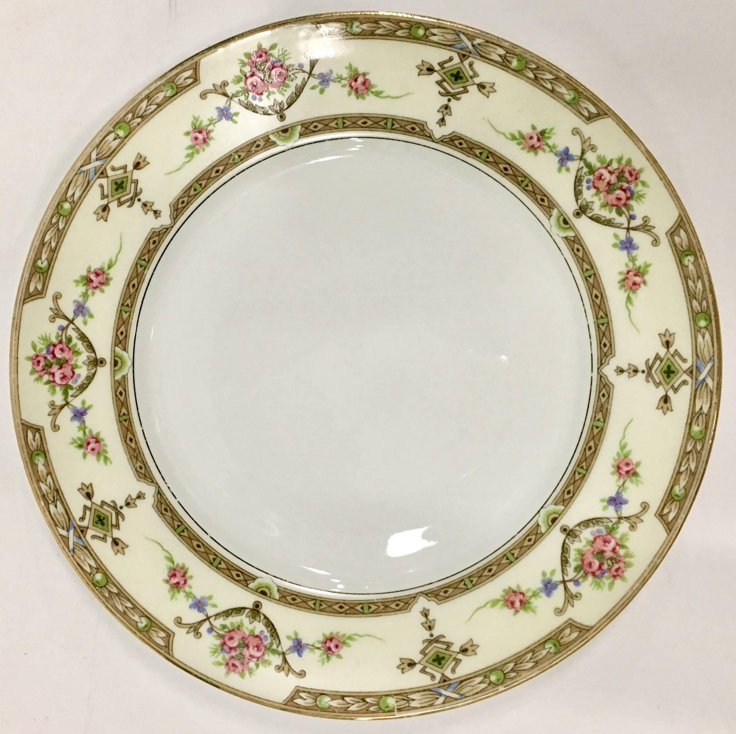 Mid-Century Art Nouveau style French porcelain dinnerware in the pattern, "Lafayette" by, U.C. Limoges France. This 14 piece set features a floral and geometric edge pattern on a cream ground. The centre well of each piece is bright white.