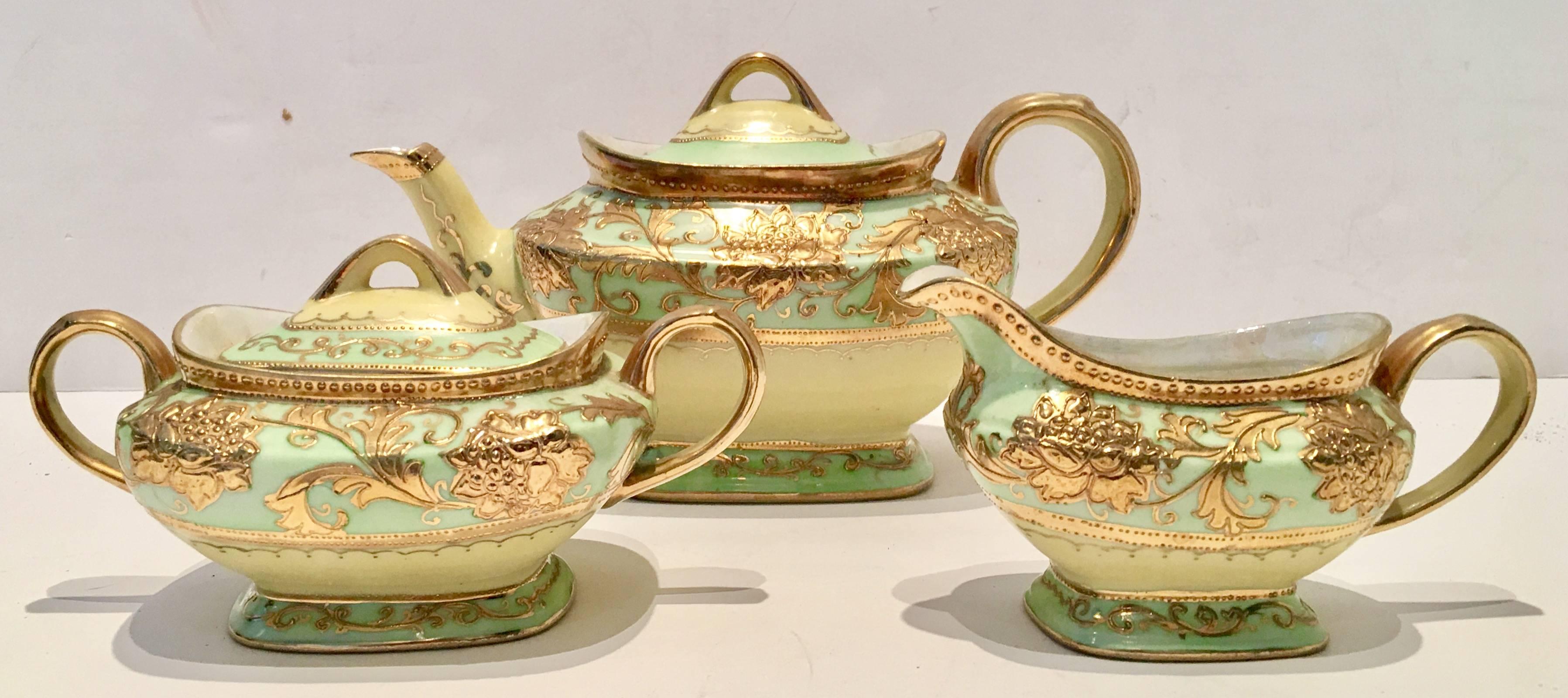 Stunning hand-painted porcelain luster ware raised 22-karat gold with pistachio green and butter yellow partial tea set. This 18 piece set includes, tea or coffee pot with lid, sugar bowl with lid, creamer, three dessert plates, six tea cups and