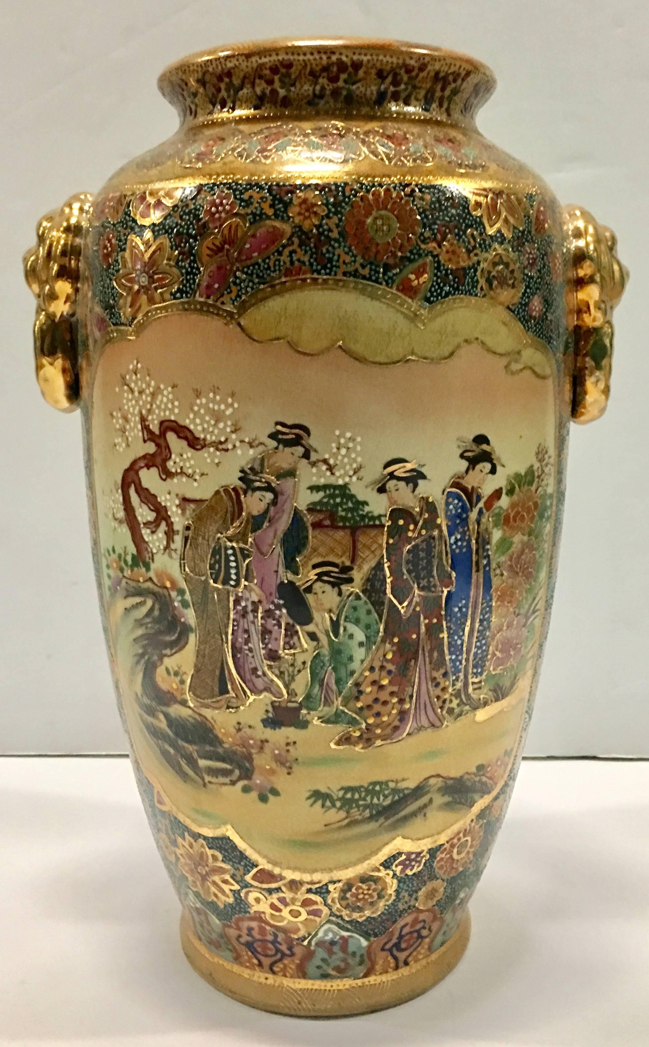 Japanese hand-painted Moriage and 22-karat gold detail Geisha two sided gold lion handle vase. Features women bonsai gardening scene on both sides, with heavy raised moriage and gold detail.