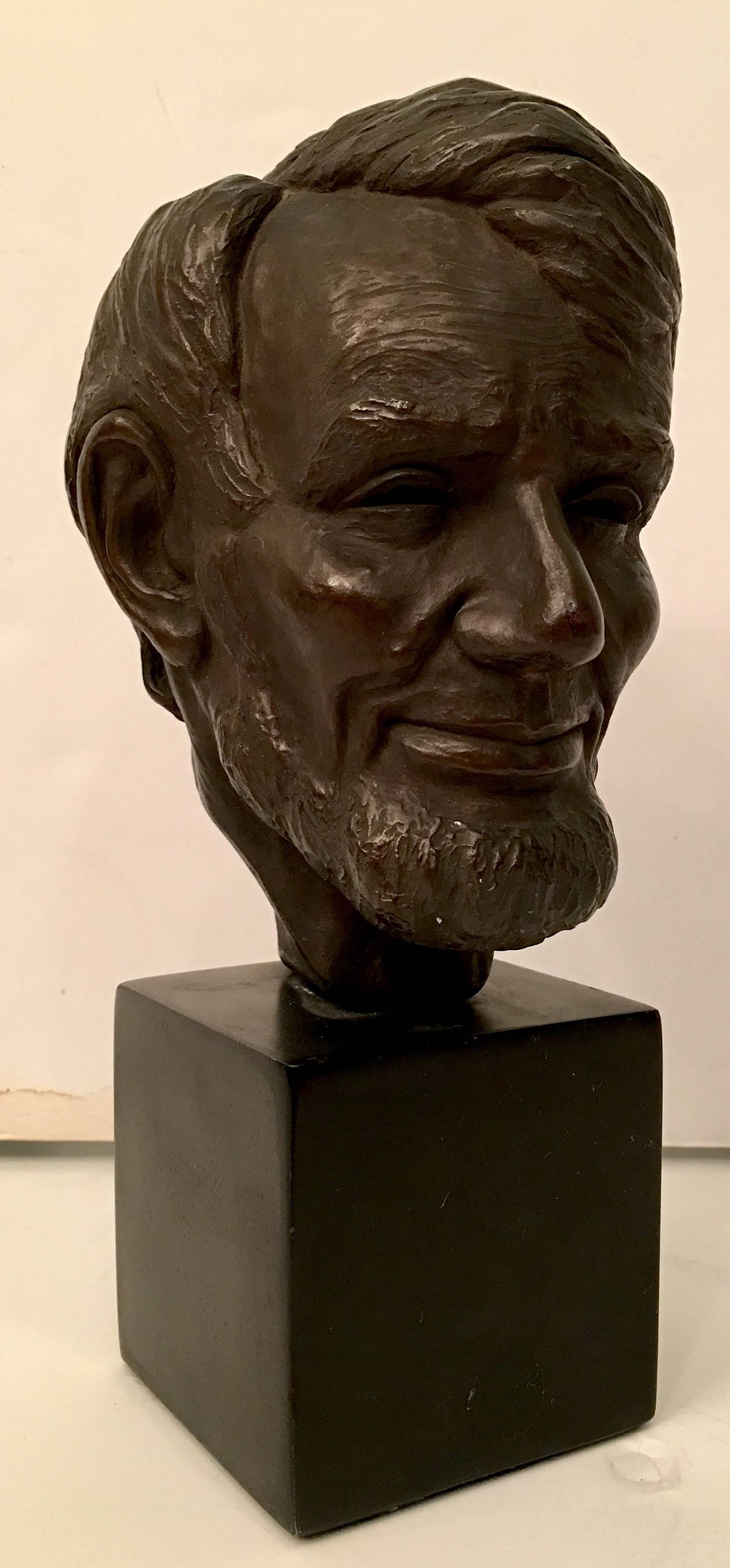 Mid-Century bronze sculpture bust of Abraham Lincoln signed, Heilbo 56. Features a black wood base.