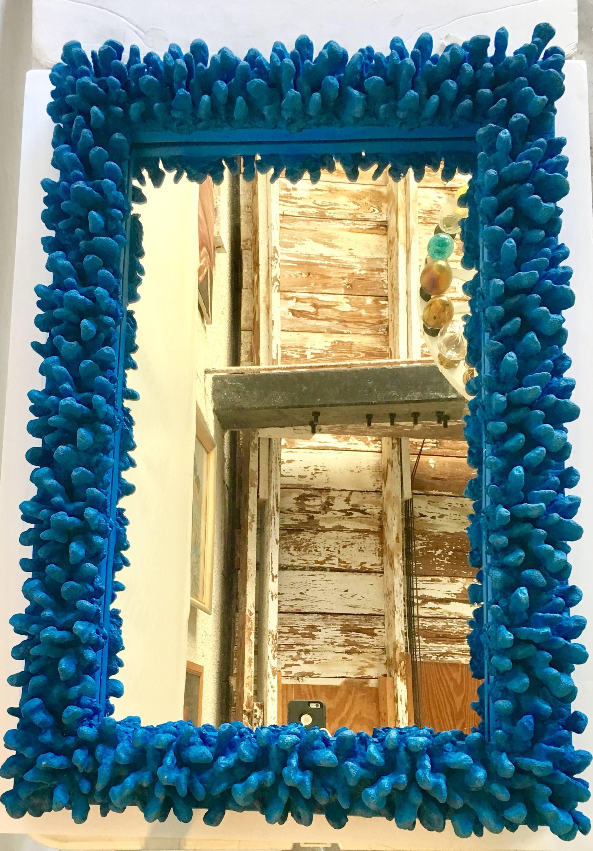 Fantastic contemporary large faux coral electric blue mirror. Features, dyed faux coral made of resin and mounted on wood frame. This piece of "art" is finished on the back side and be hung horizontally and or vertical. Current hanging