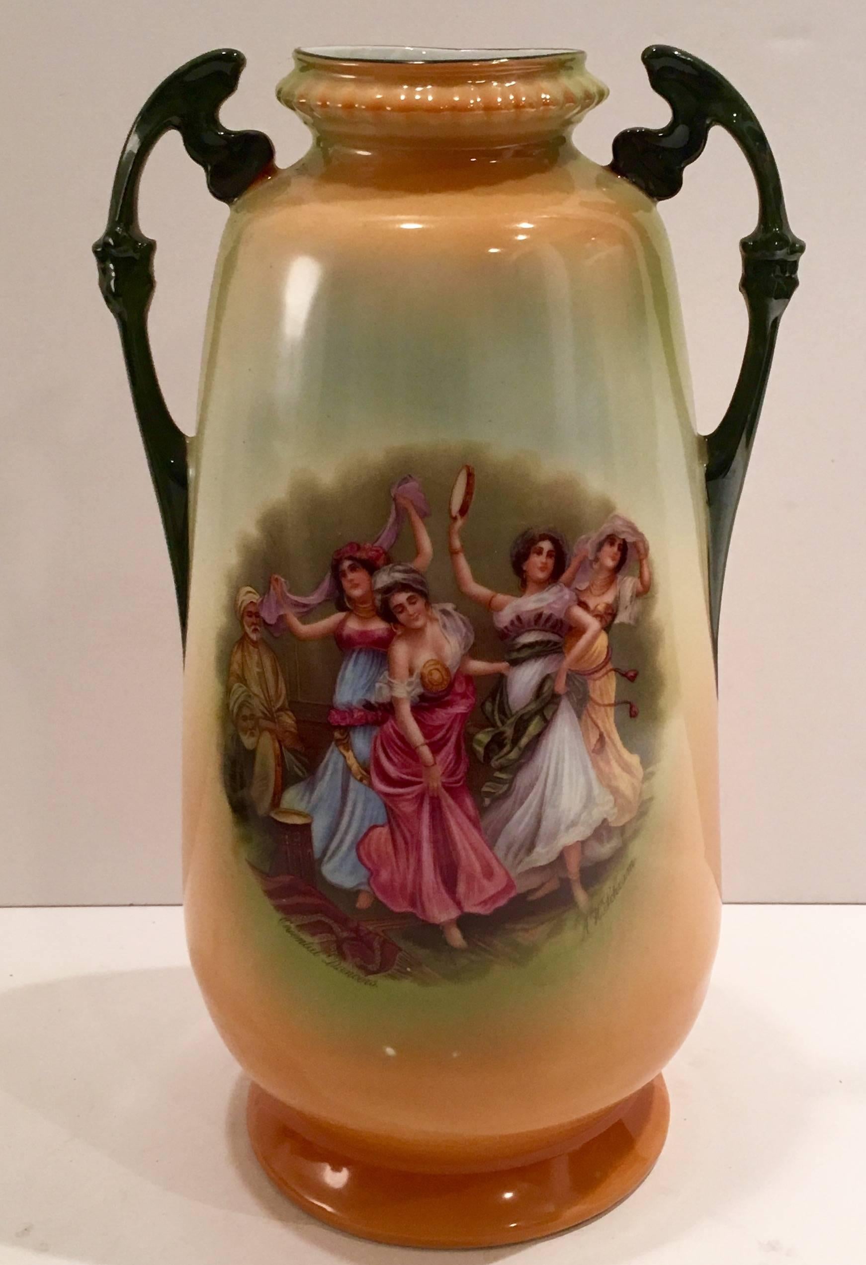 Antique porcelain hand-painted two handle vase, signed and titled on front. This gorgeous and rare piece is titled, Oriental Dancers and signed by the artist A H. Schram front. Signed Victoria Austria on underside.
