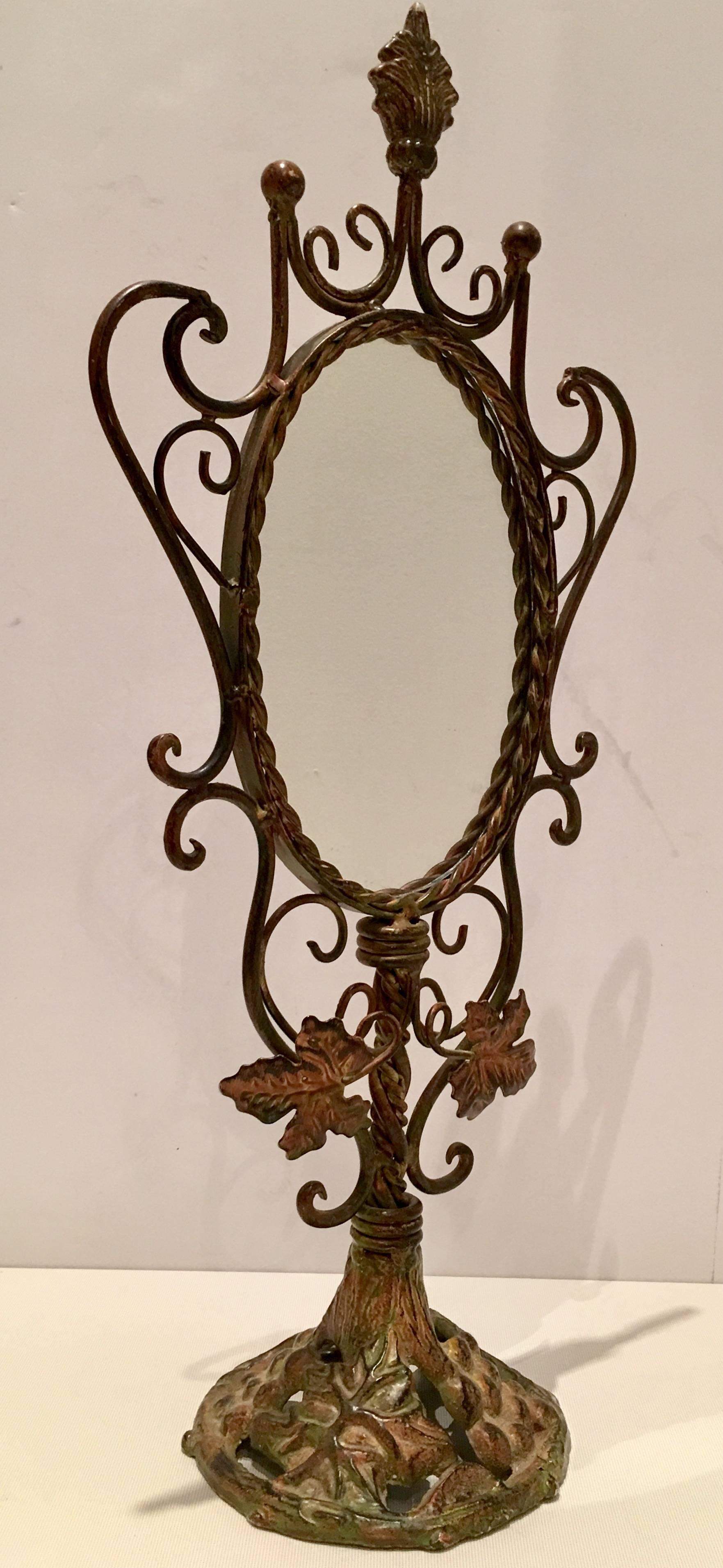 Art Nouveau bronze patina grape vine motif standing vanity mirror.