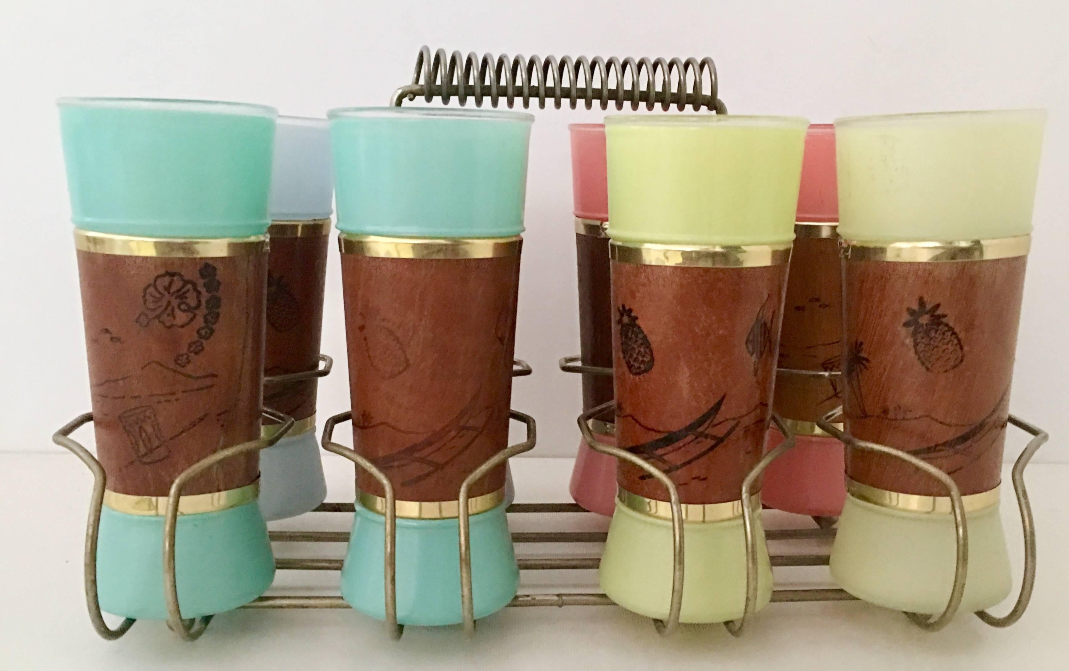 1950'S Hawaiian Luau themed frosted glass and brass mahogany wrap drink glasses with brass and mahogany carrying caddy.
Set includes eight glass tumblers, two in each color way and a eight slot brass and mahogany handle carrying caddy. Each glass is