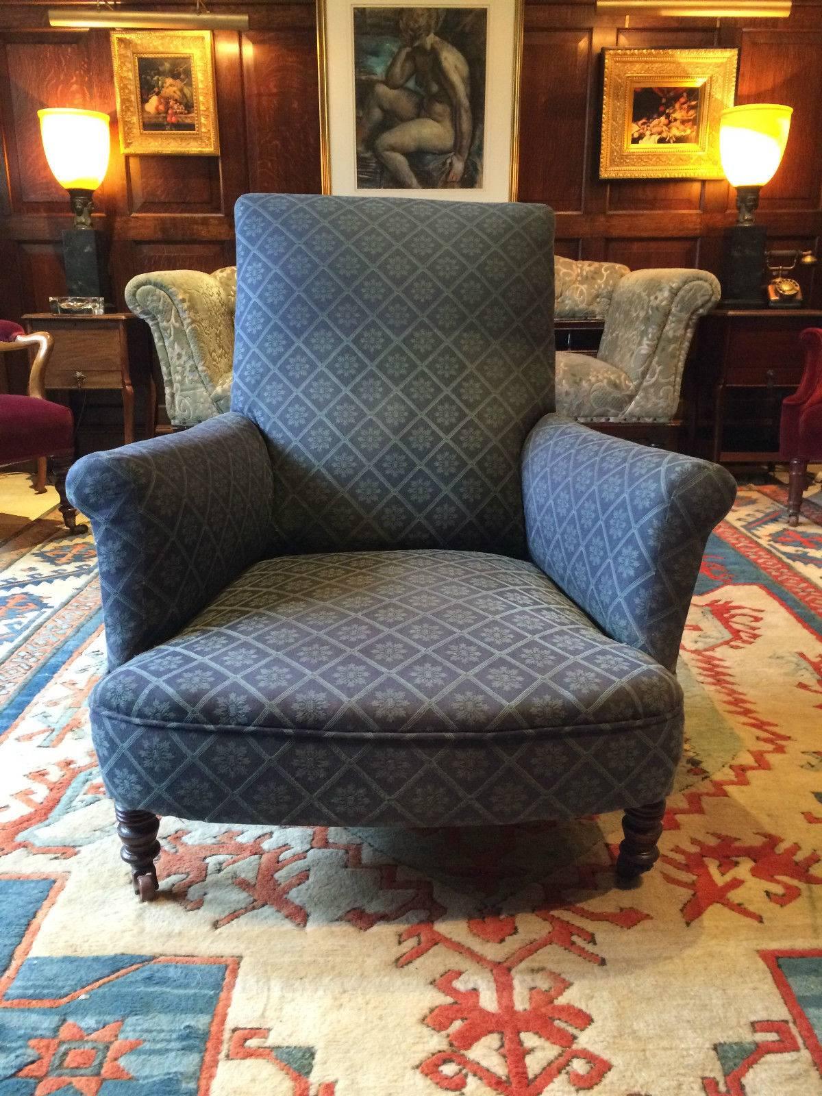 A beautiful 19th century Howard & Sons style mahogany ‘Club Chair’ armchair with gorgeous low, long sweeping seat and curved back, dressed in a blue and green material and standing on turned front legs with casters, chair is ideal for reupholstering